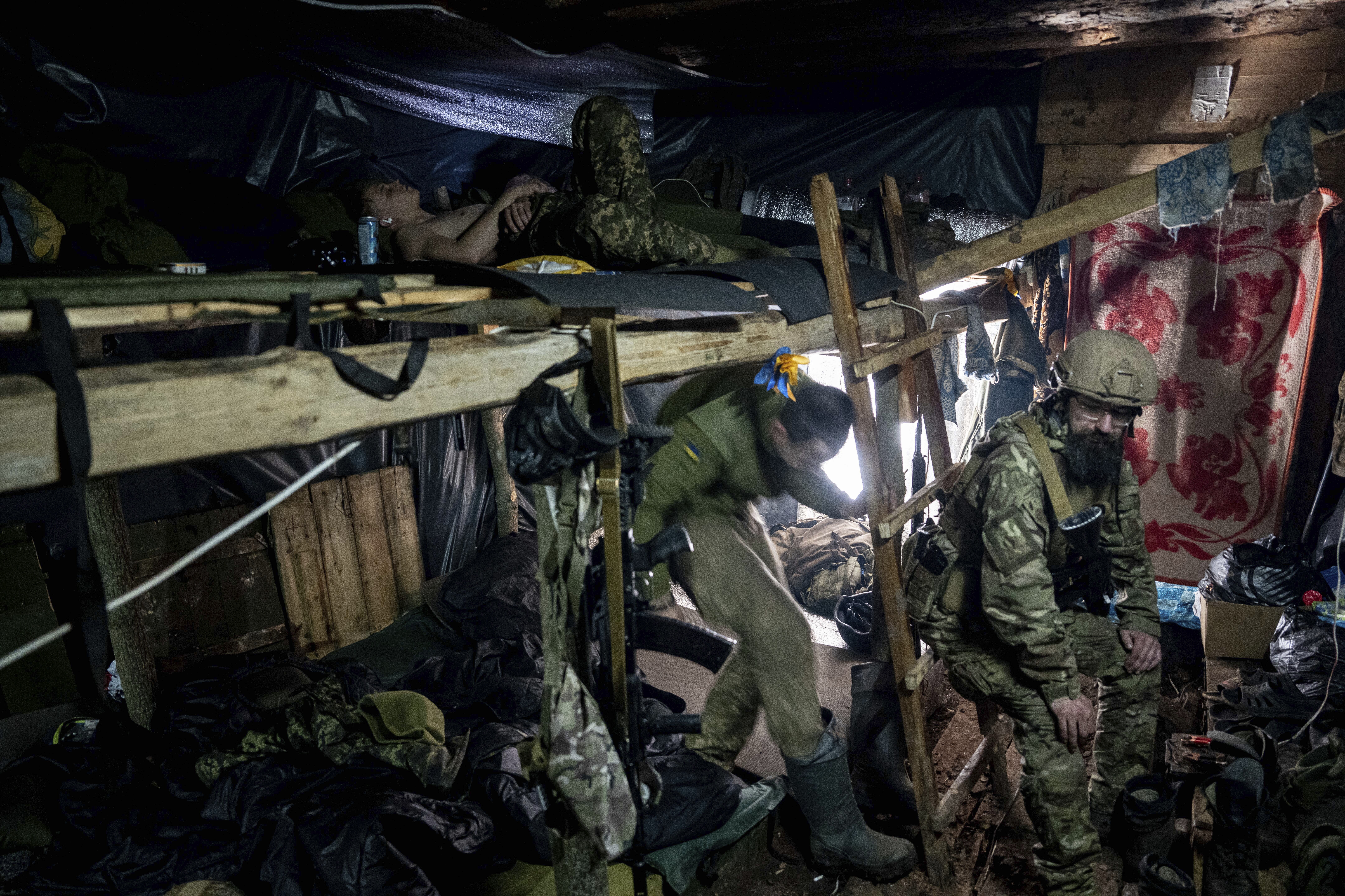 Soldiers in a dig out near the front line in Bakhmut, Ukraine. They are resting on bunks.