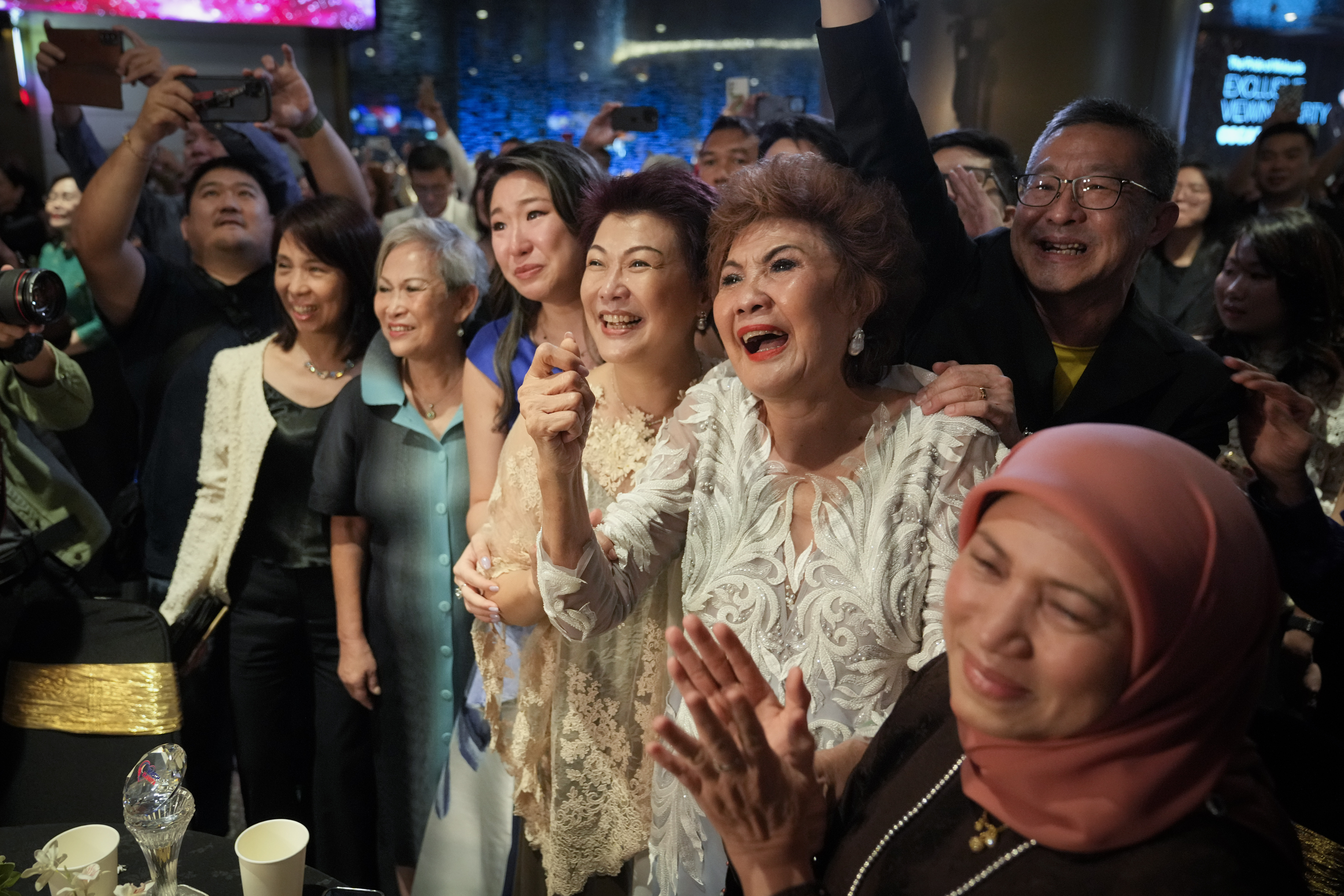 Janet Yeoh, second right, mother of Michelle Yeoh, celebrates after her daughter won in the best actress category during the 95th Academy Awards in Los Angeles