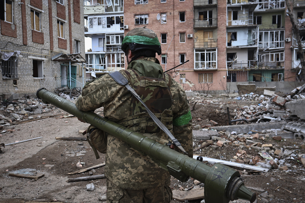 Ukrainian soldier carries a portable anti-aircraft missile system in the area of the heaviest battles with the Russian invaders in Bakhmut, Donetsk region, Ukraine, Wednesday, March 15, 2023. (AP Photo/Roman Chop)
