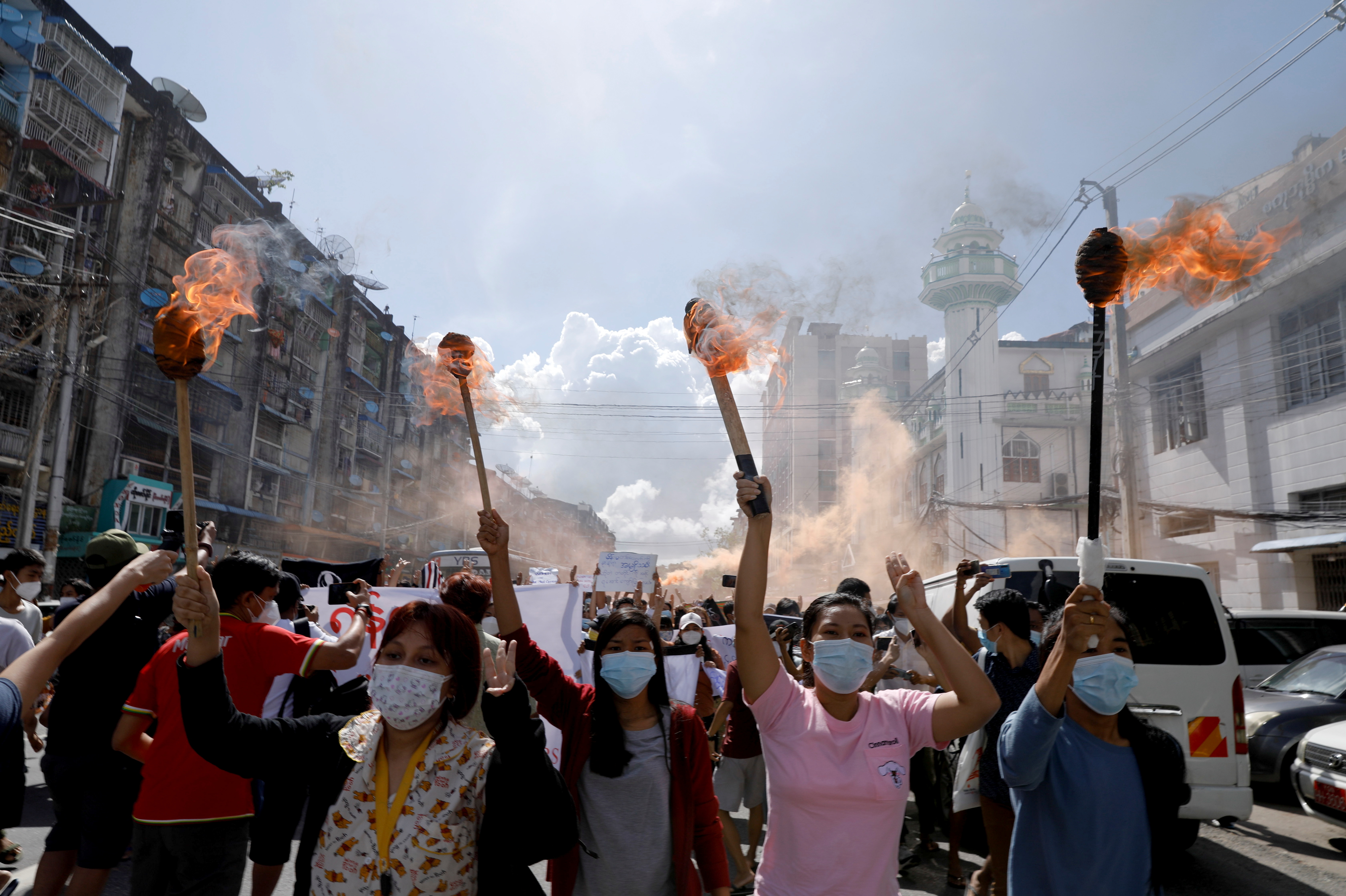 A group of women hold torches high above their heads as they protest against the military coup in Yangon, Myanmar July 14, 2021. REUTERS/Stringer