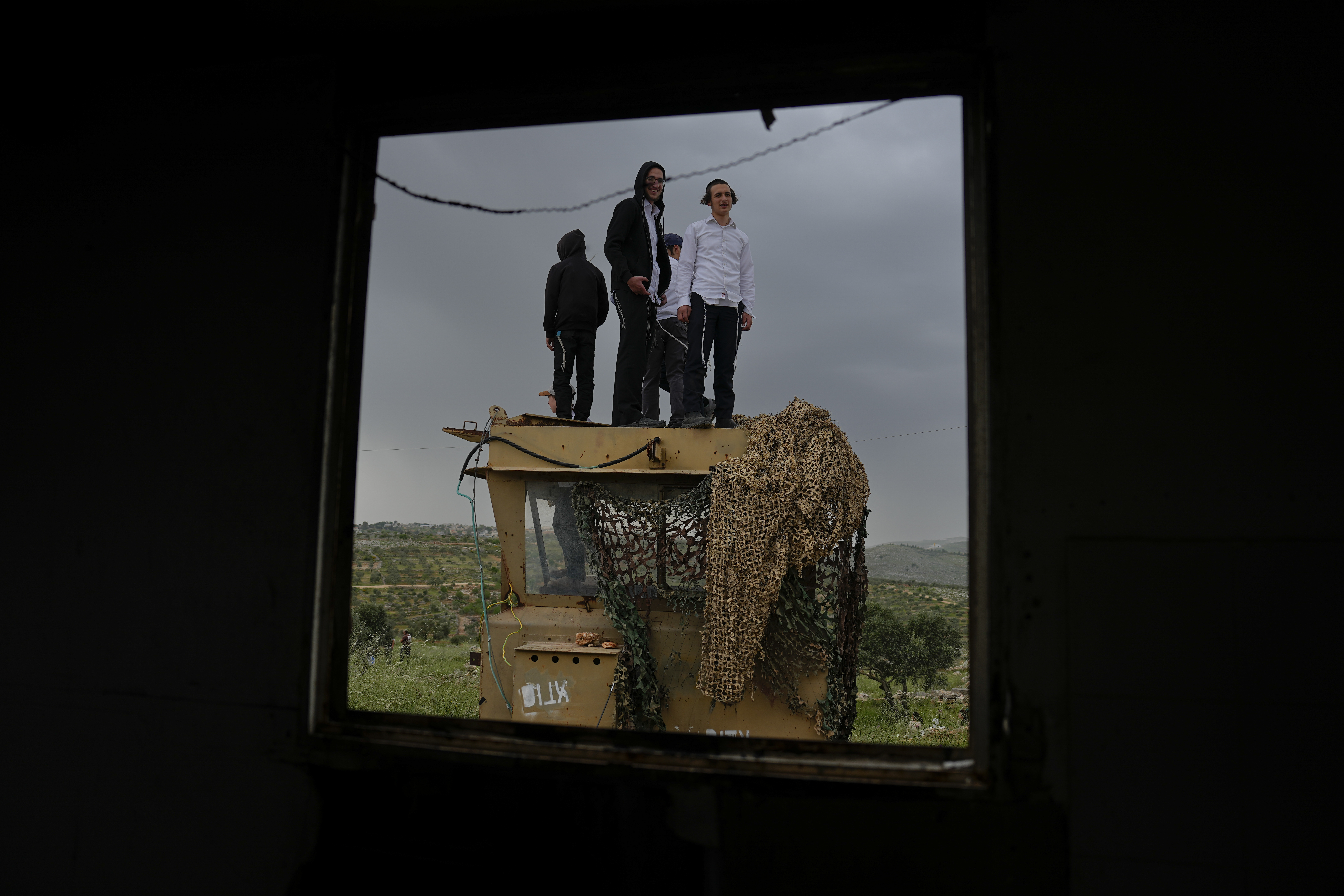Israeli settlers stand in the outpost of Eviatar