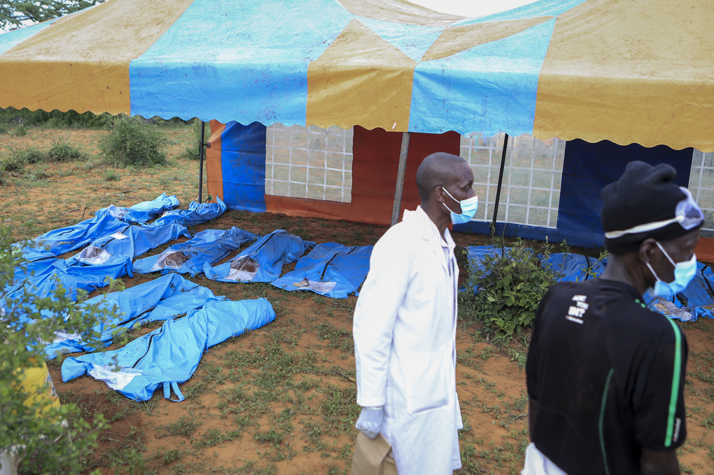 Some of the exhumed bodies of victims of a religious cult are laid out under blue tarpaulins in the village of Shakahola, near the coastal city of Malindi, in southern Kenya on April 23, 2023.