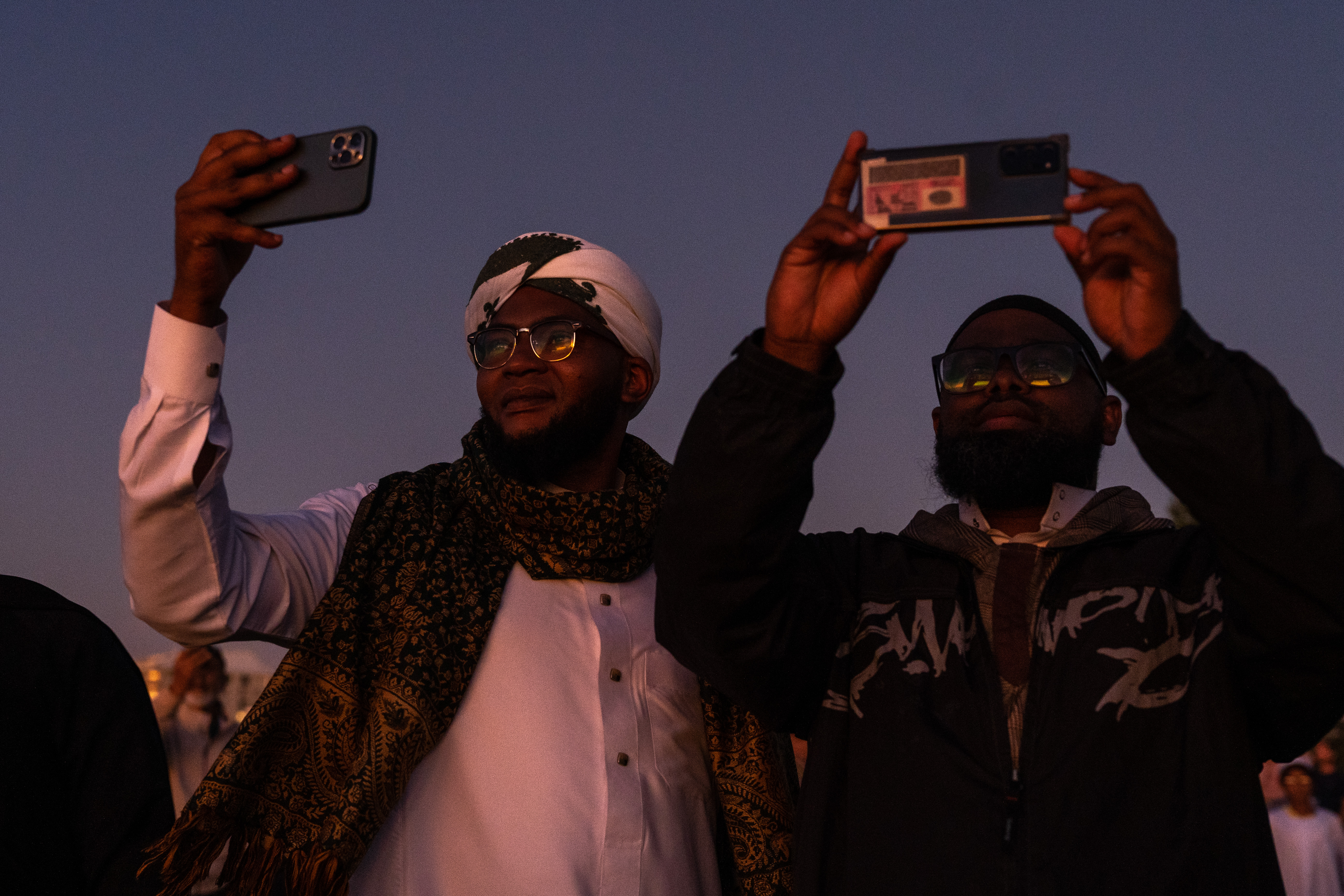 Men use their smartphones to photograph the sky at a moon sighting in Cape Town
