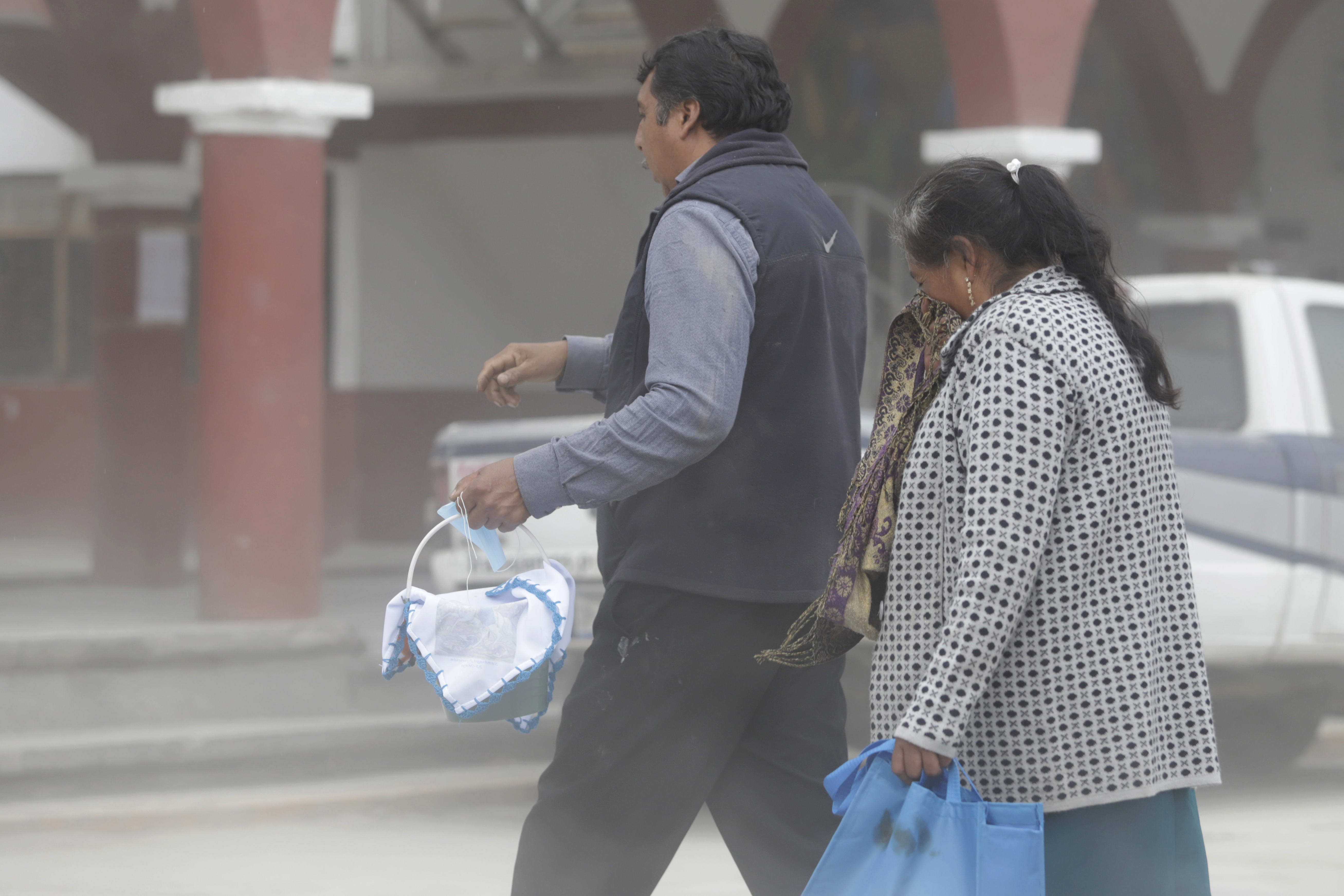 People walk through ash caused by the activity of Popocatepetl volcano,