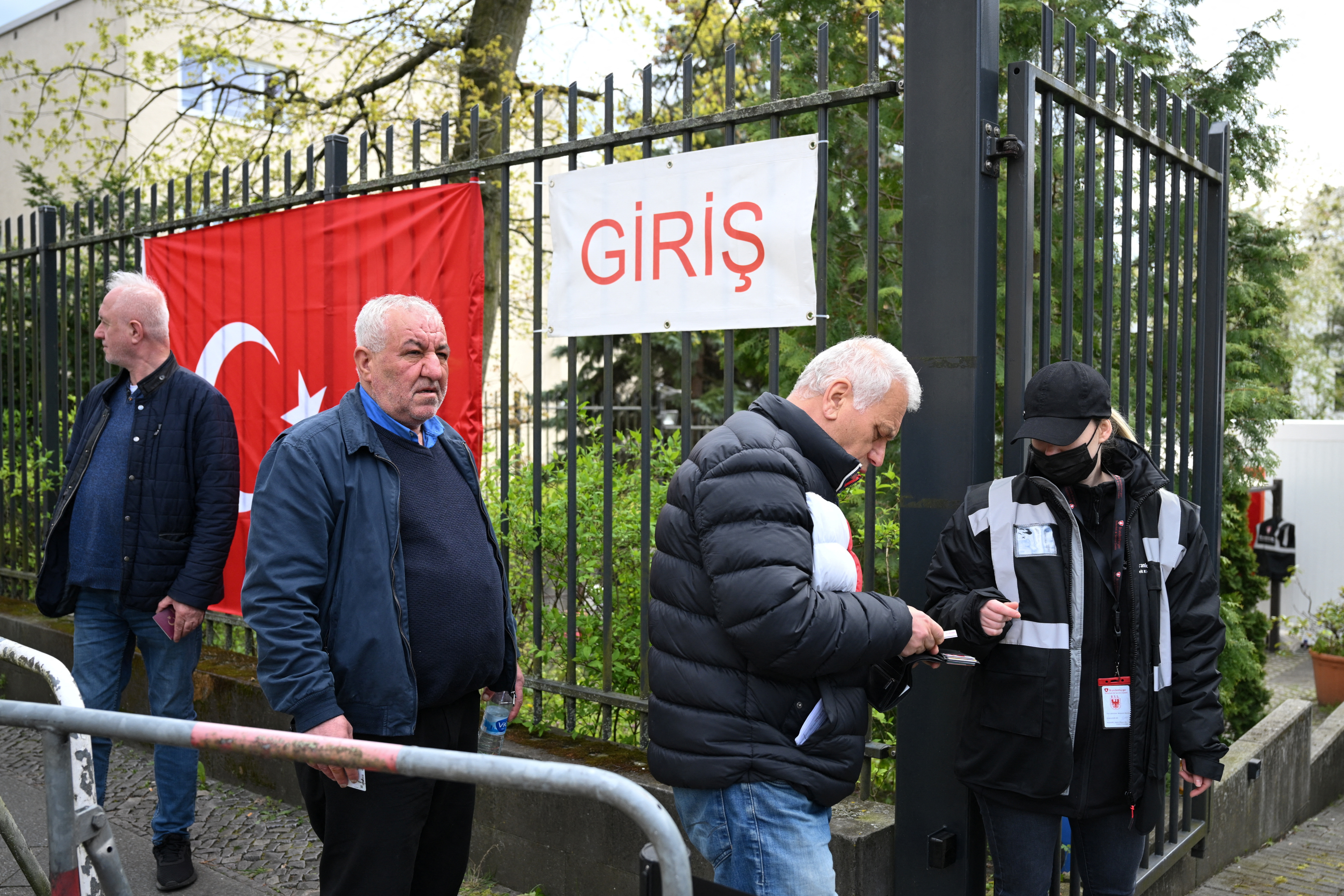 A Turkish citizen living in Germany is checked by a security person before entering the Turkish consulate in Berlin to vote for the parliamentary and presidential elections