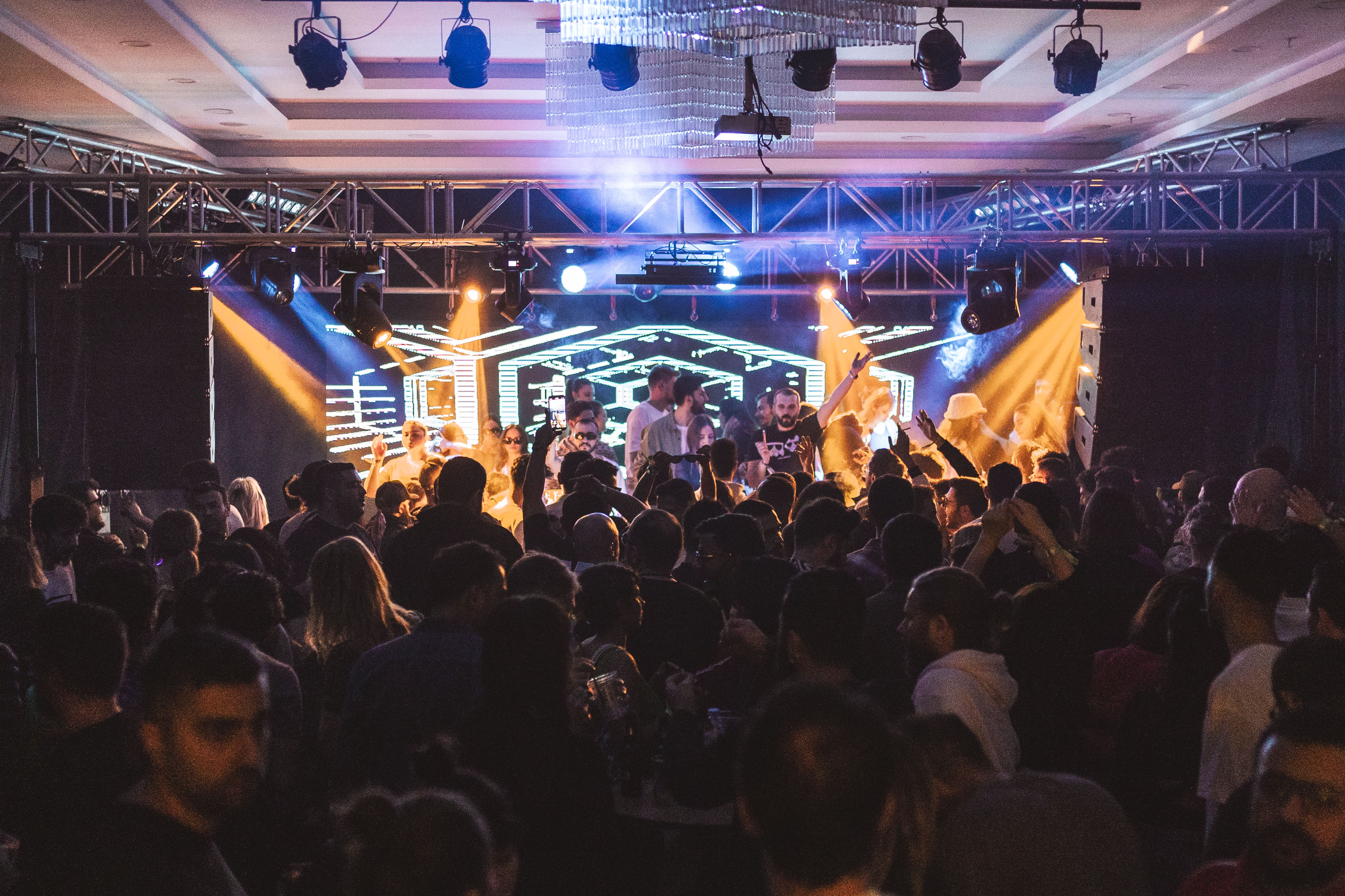 A photo of a concert with a large audience standing.