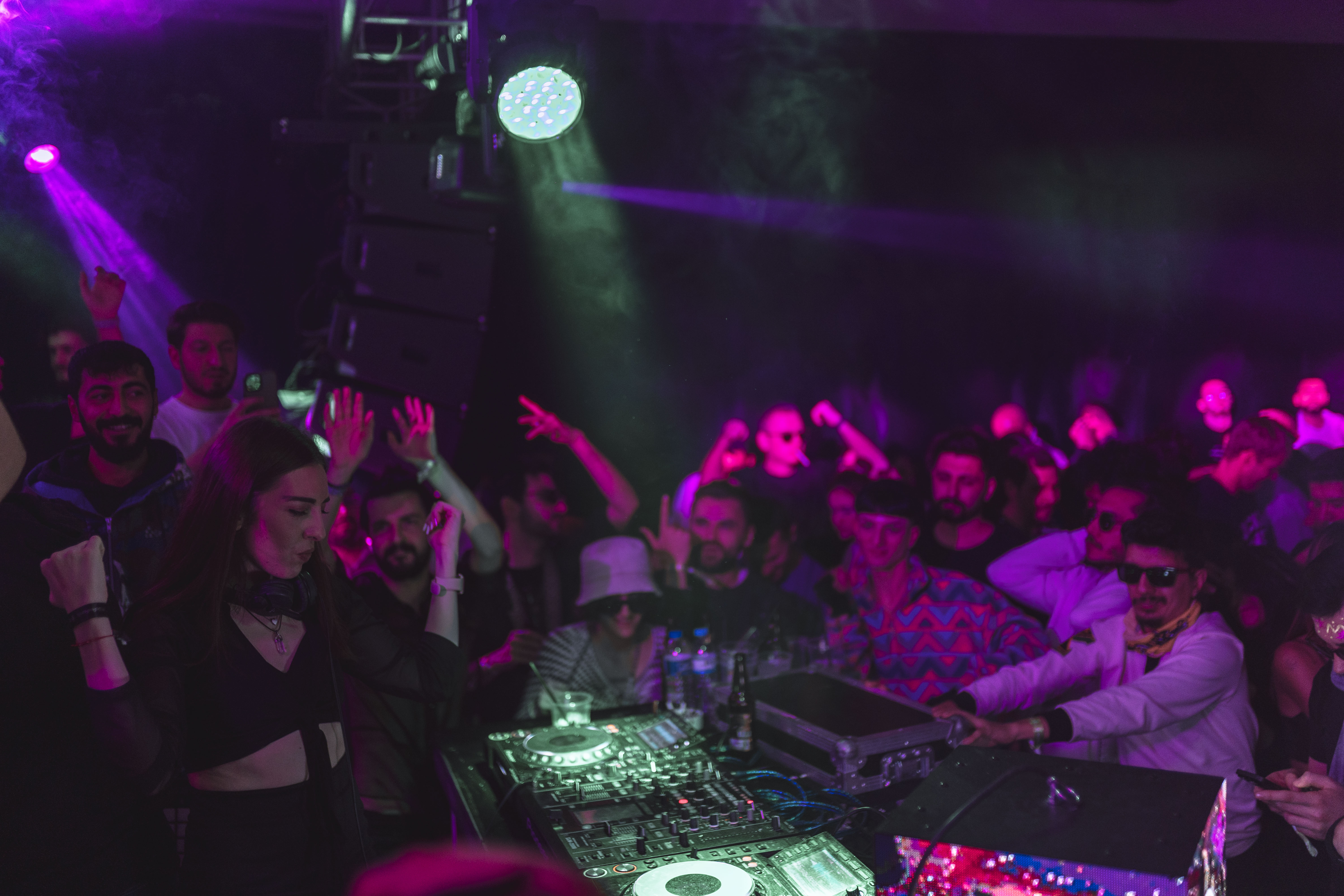 A photo of a group of people standing around a DJ.