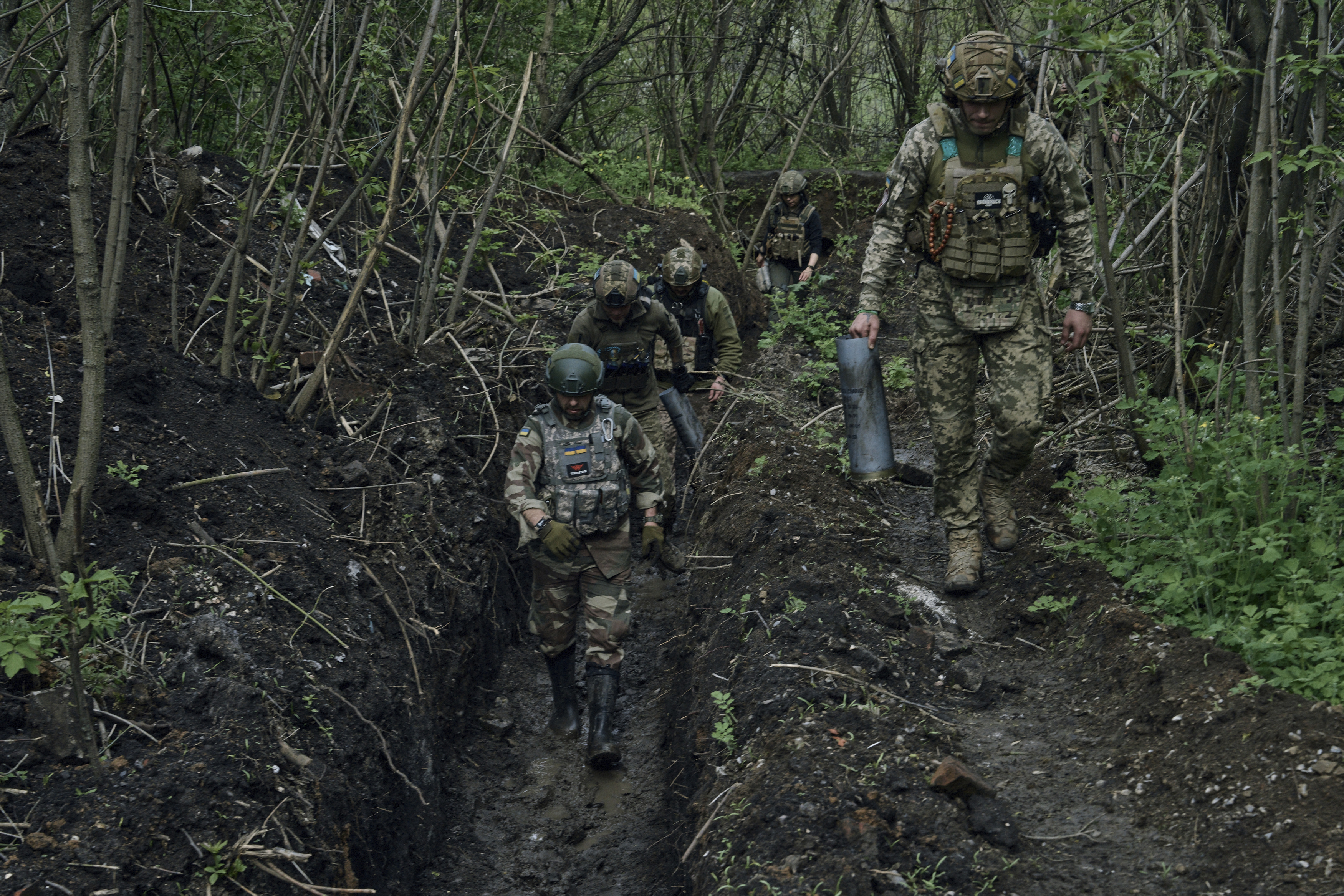 Ukrainian soldiers walk in a trench near Bakhmut, an eastern city where fierce battles against Russian forces have been taking place, in the Donetsk region, Ukraine, Saturday