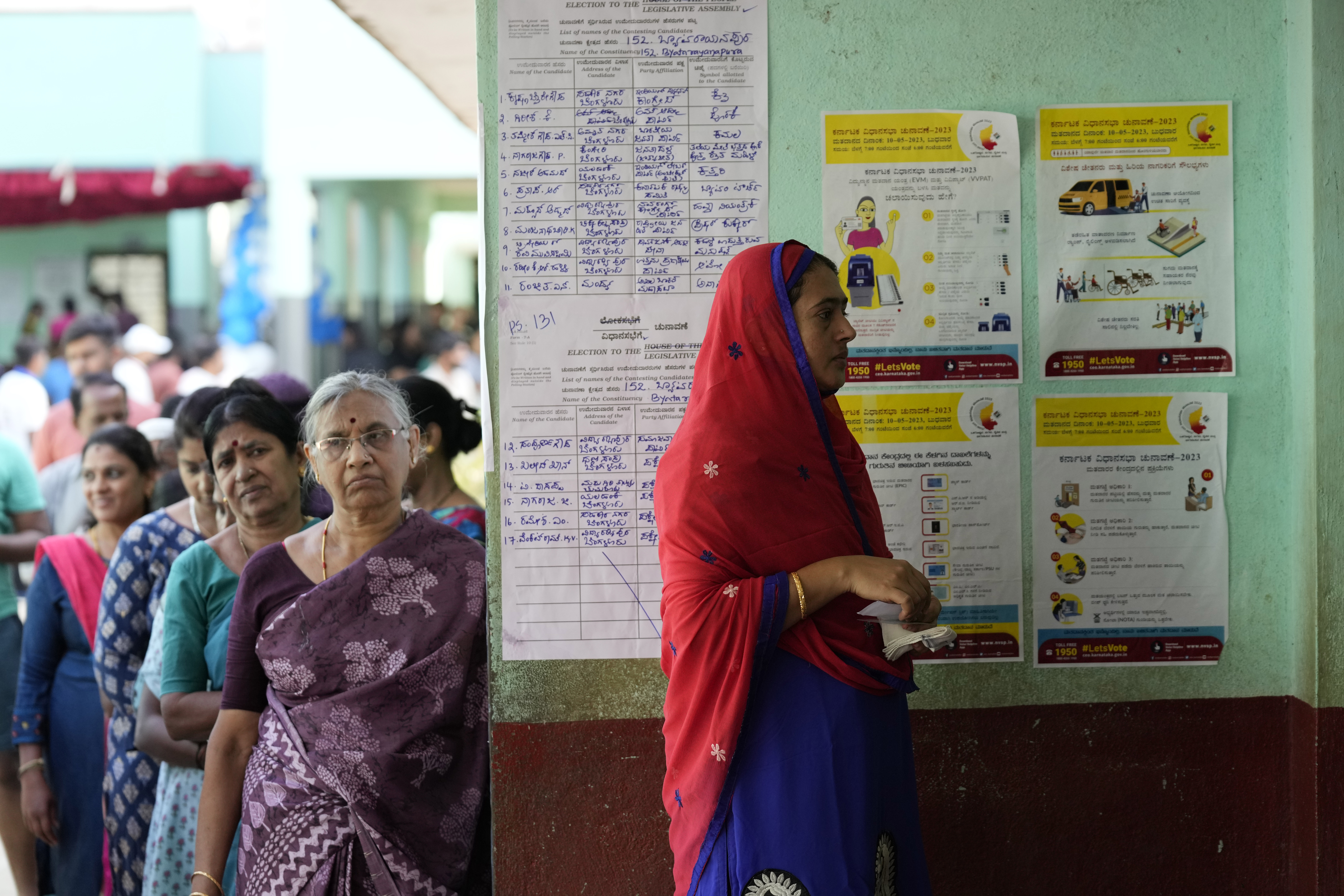 Women wait in a queue to caste their votes at a polling station in Bengaluru, India