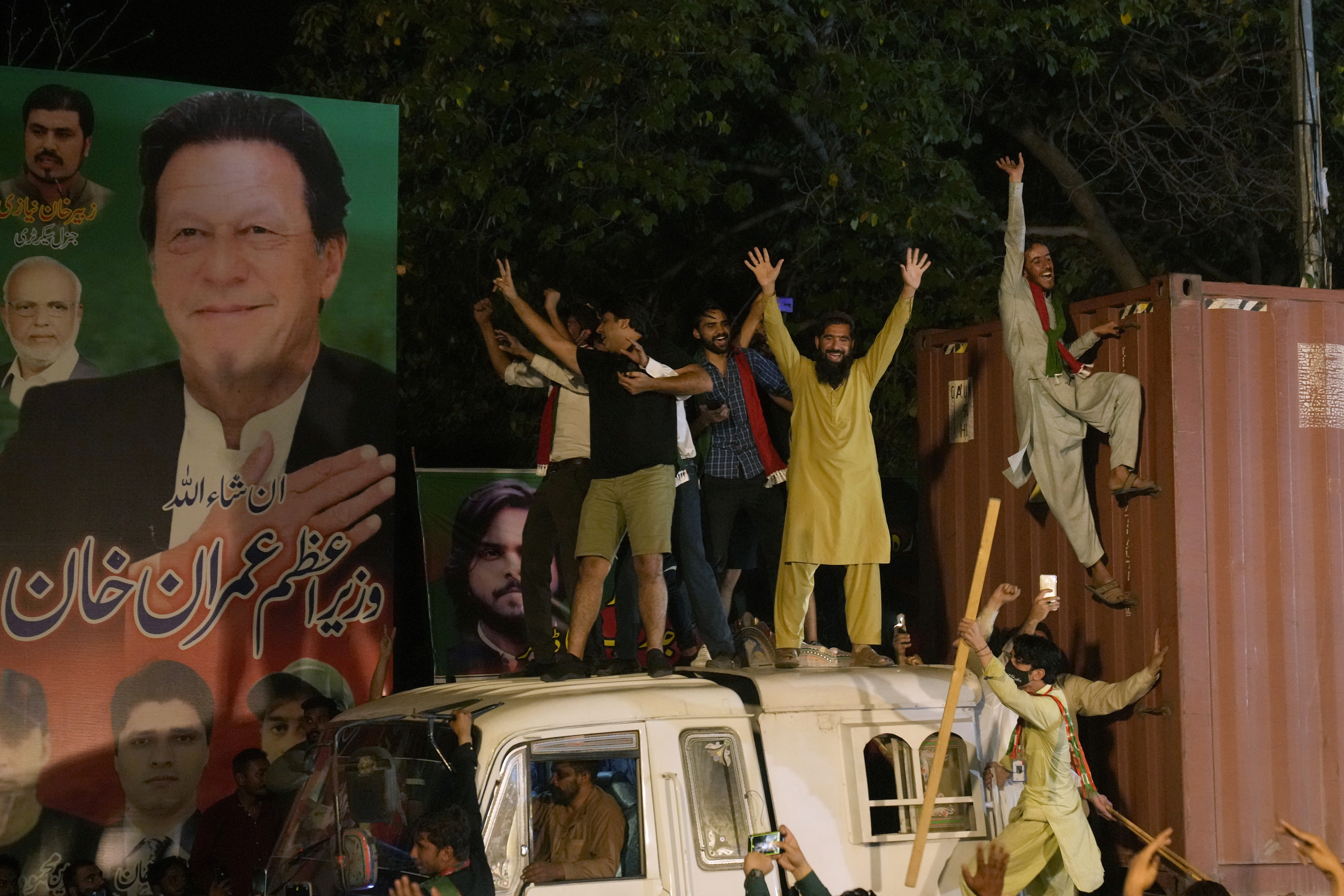 Supporters of former Prime Minister Imran Khan greet their leader upon is arrival at his home in Lahore