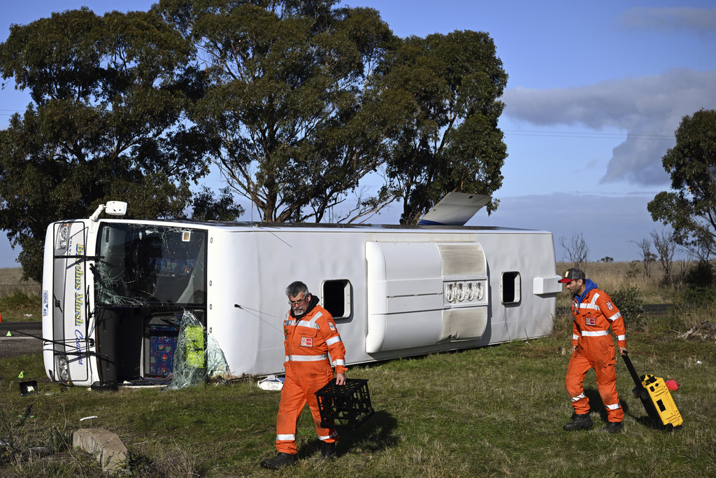 Investigators work at the scene of a bus crash near in Melbourne, Wednesday, May 17, 2023. Seven children remain hospitalized with serious injuries after a truck struck a school bus Tuesday carrying as many as 45 students on the outskirts of Melbourne in southeastern Australia. (Joel Carrett/AAP Image via AP)