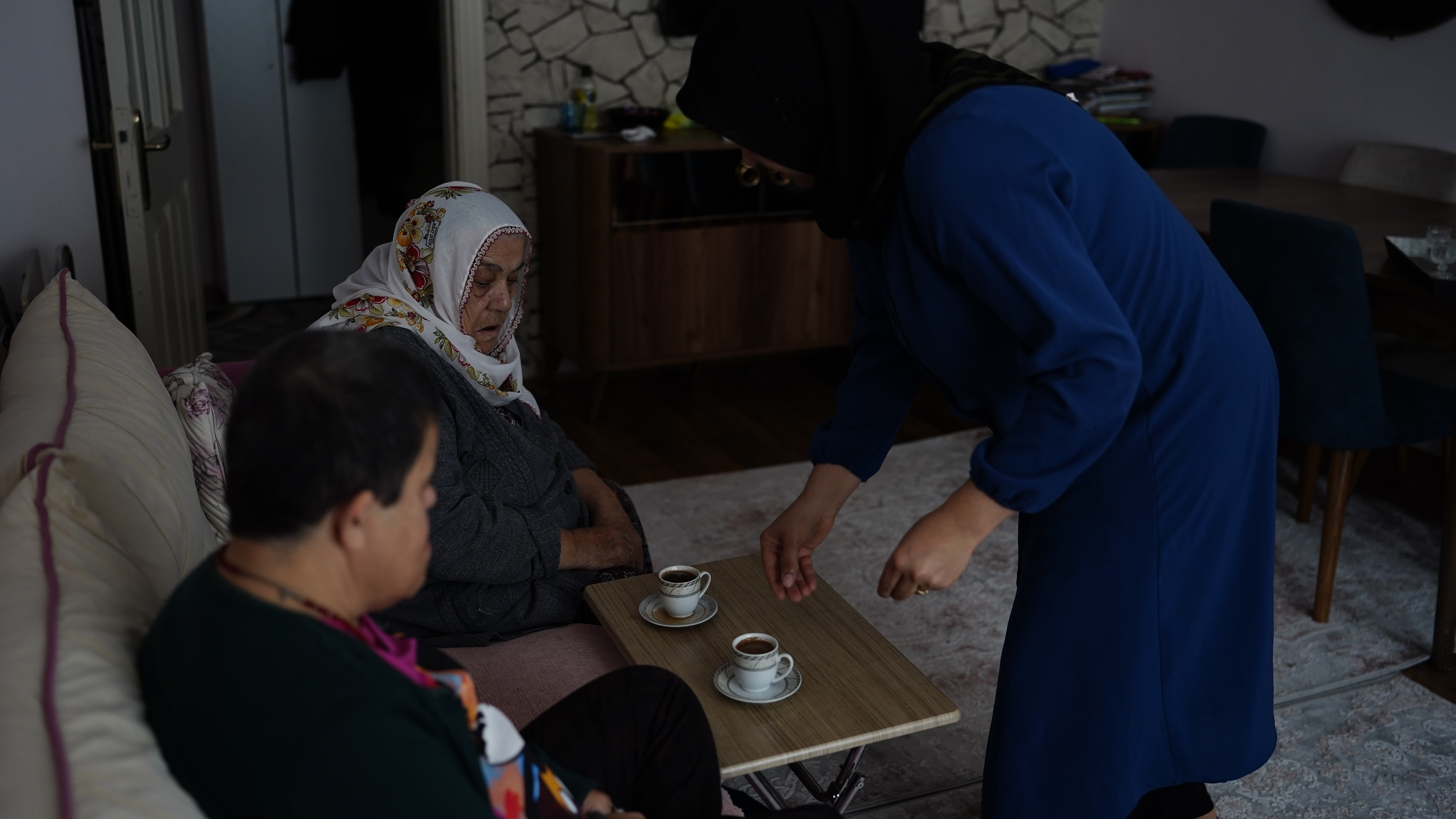 A woman serves tea in a living room