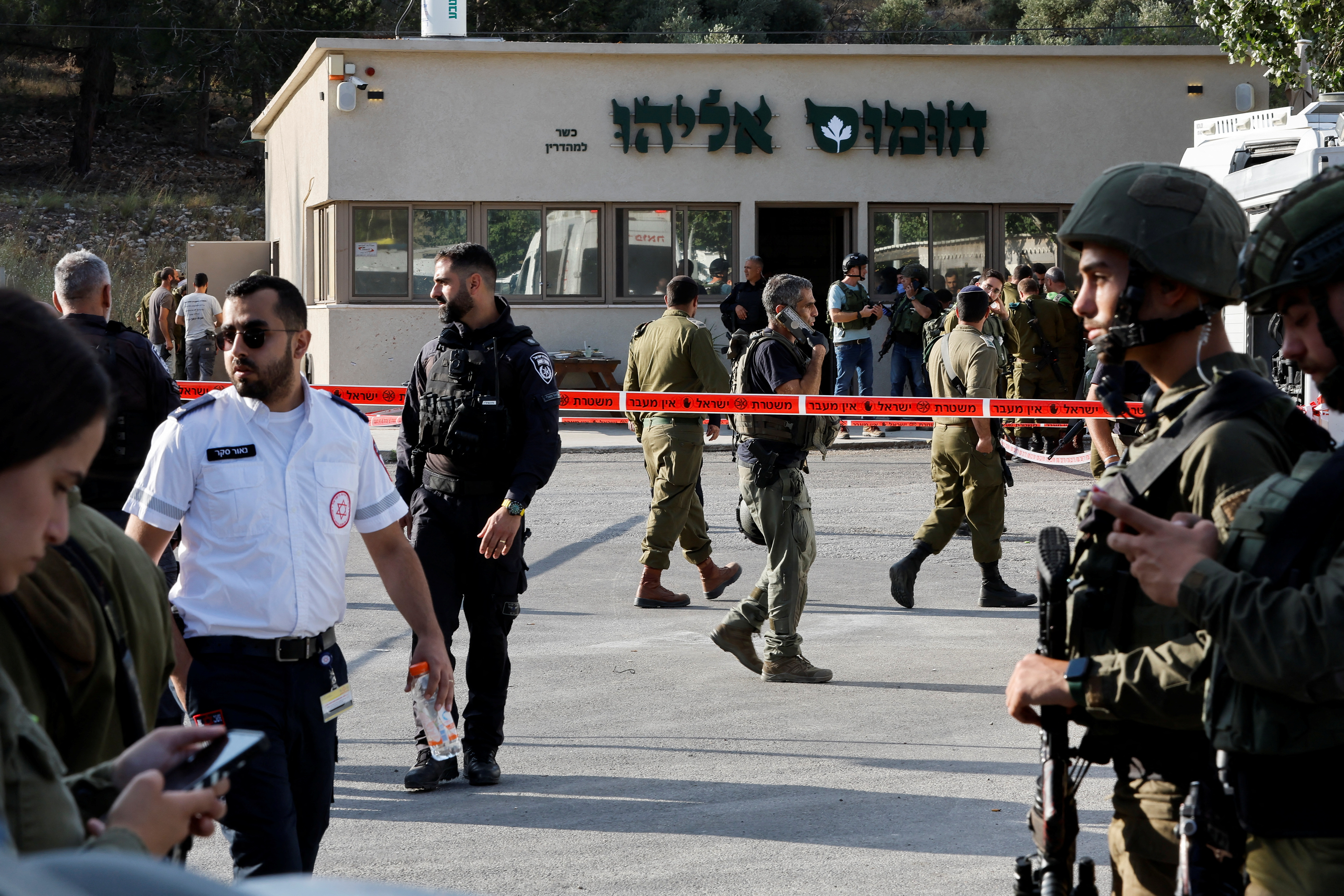 Security personnel work at the scene of a suspected Palestinian shooting attack that killed four people near the Jewish settlement of Eli,
