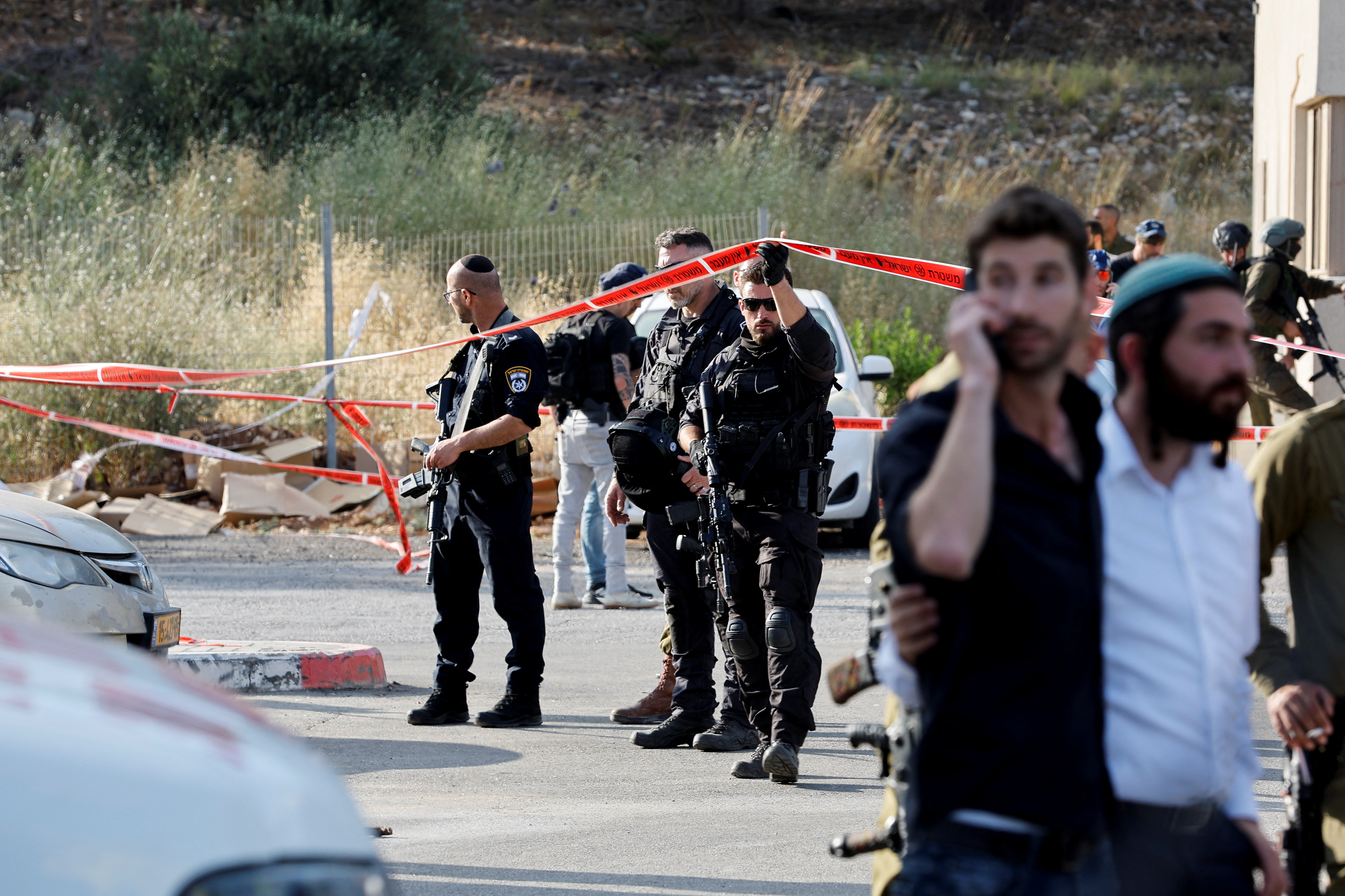 Security personnel work at the scene of a suspected Palestinian shooting attack that killed four people near the Jewish settlement of Eli