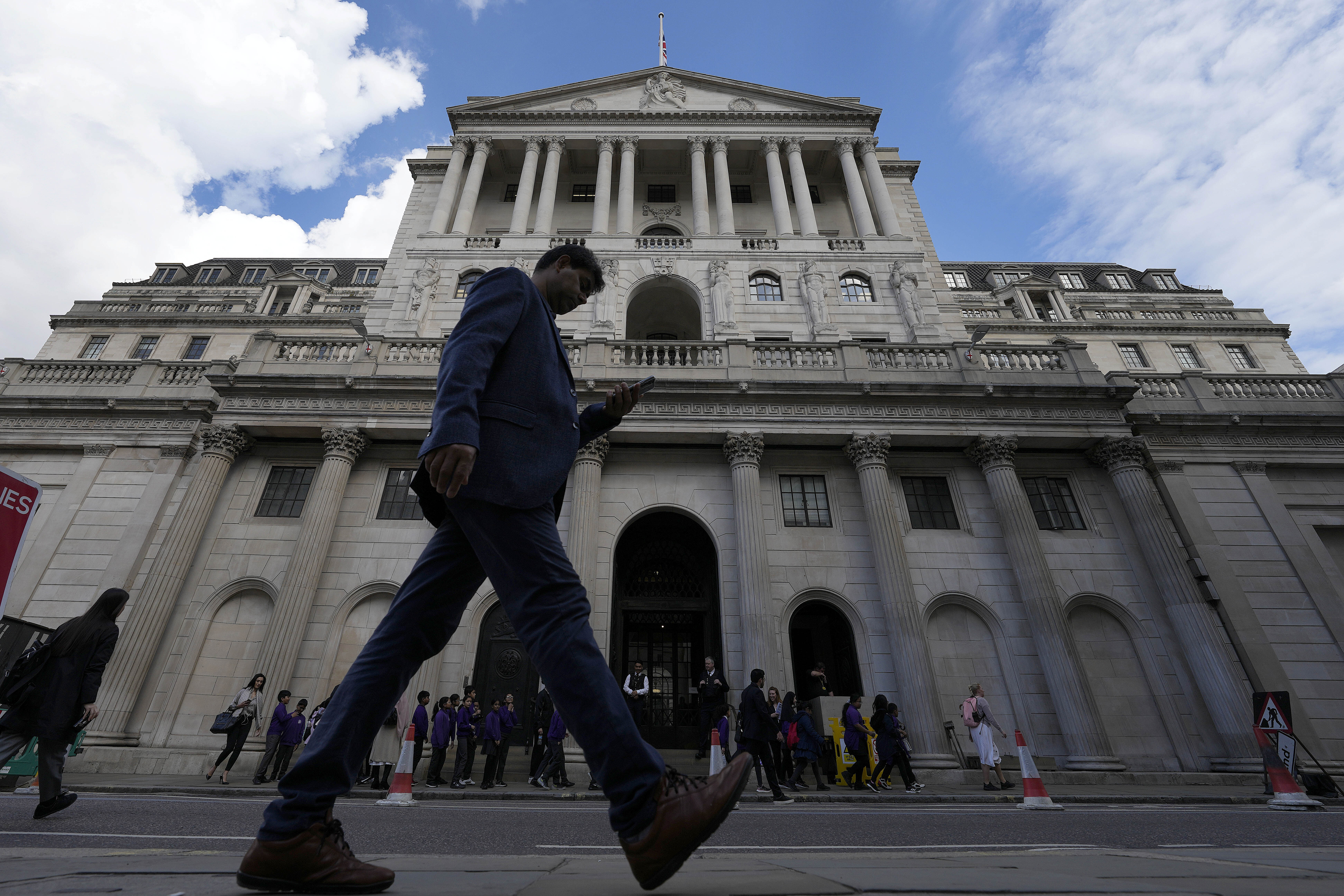 A man walks past the Bank of England, at the financial district in London, UK