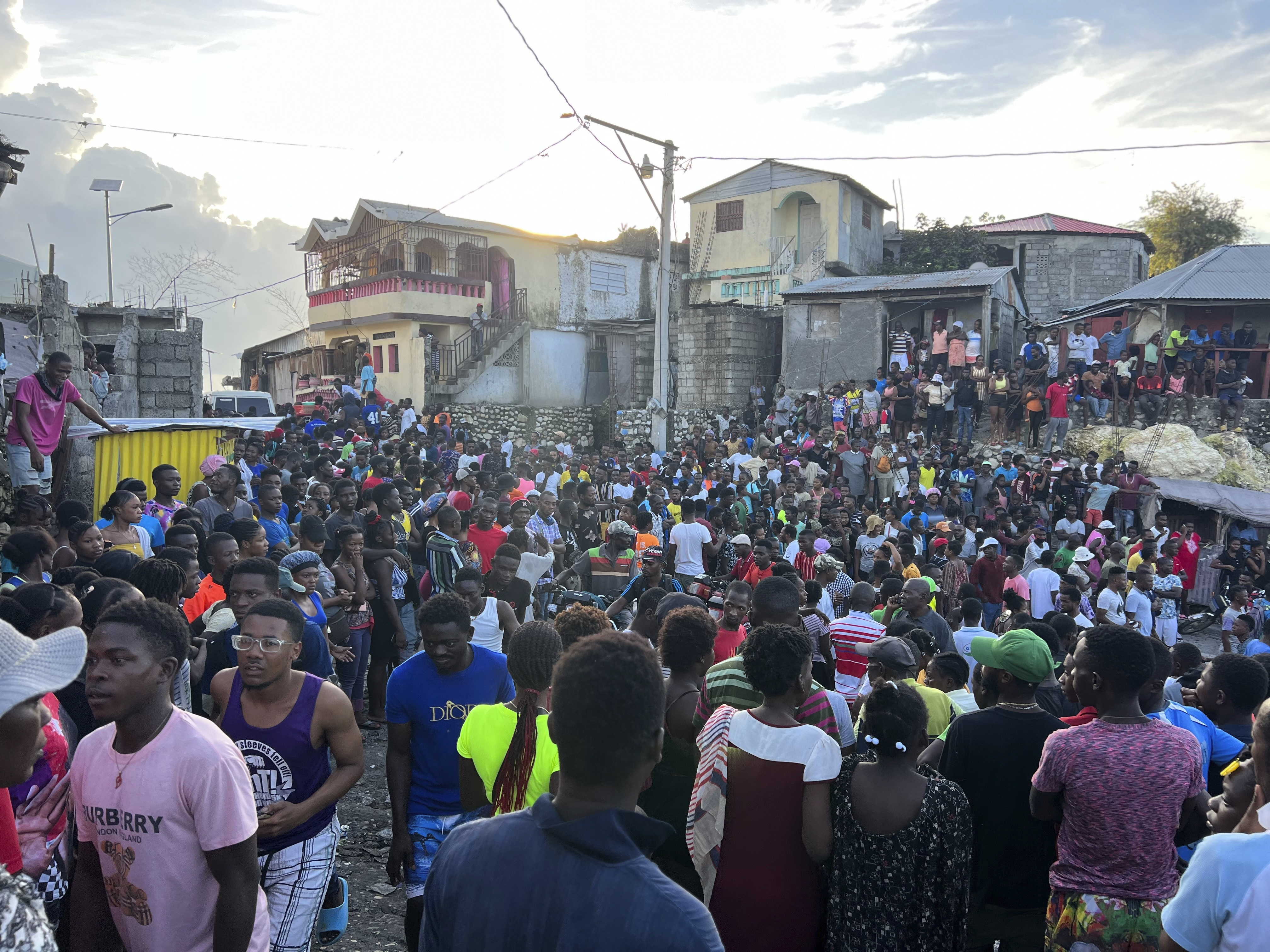 People watch rescue efforts in homes that collapsed after an earthquake
