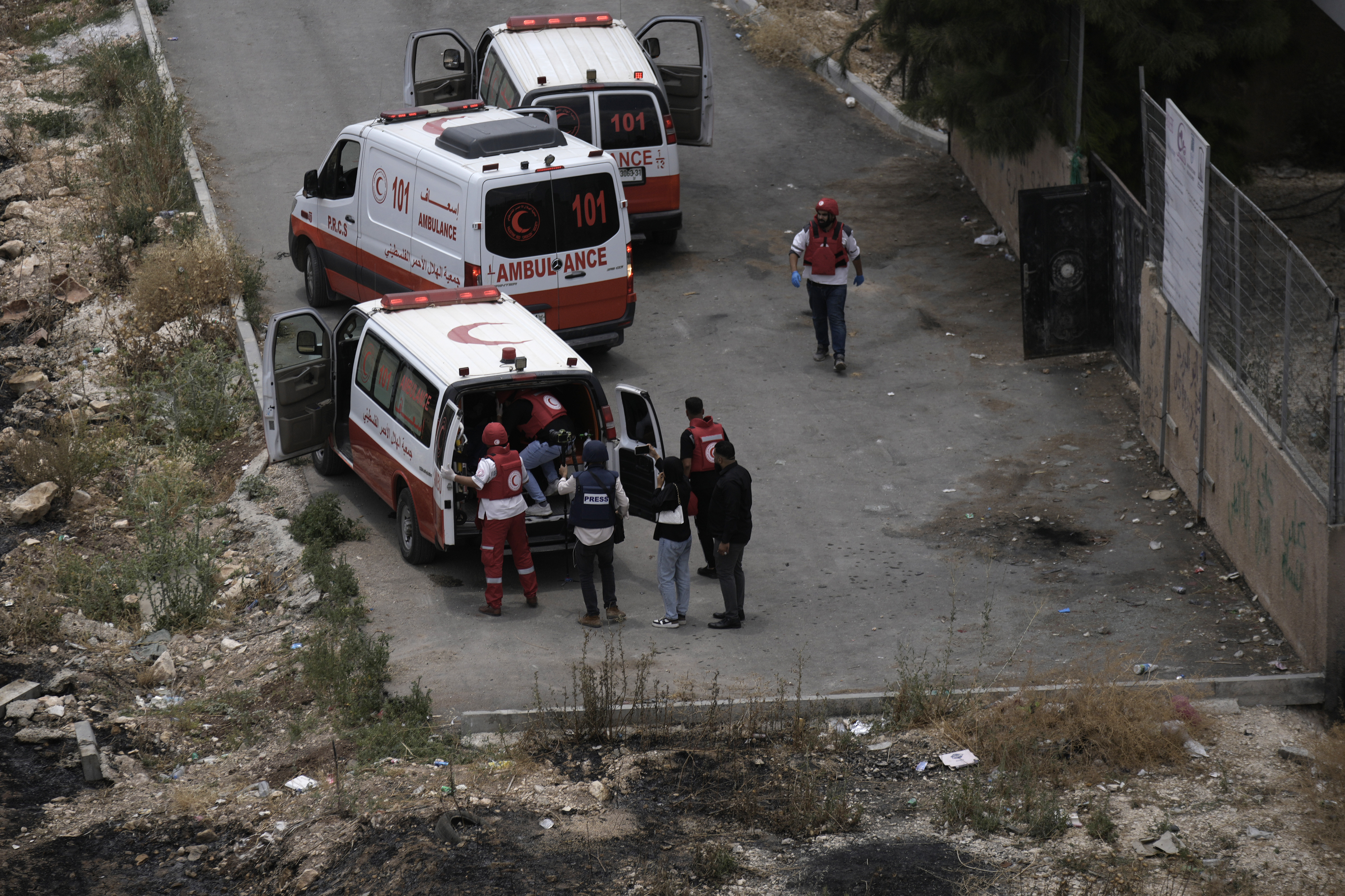 Palestinian Red crescent paramedics evacuate a journalist injured when he was shot while filming fighting between Israeli