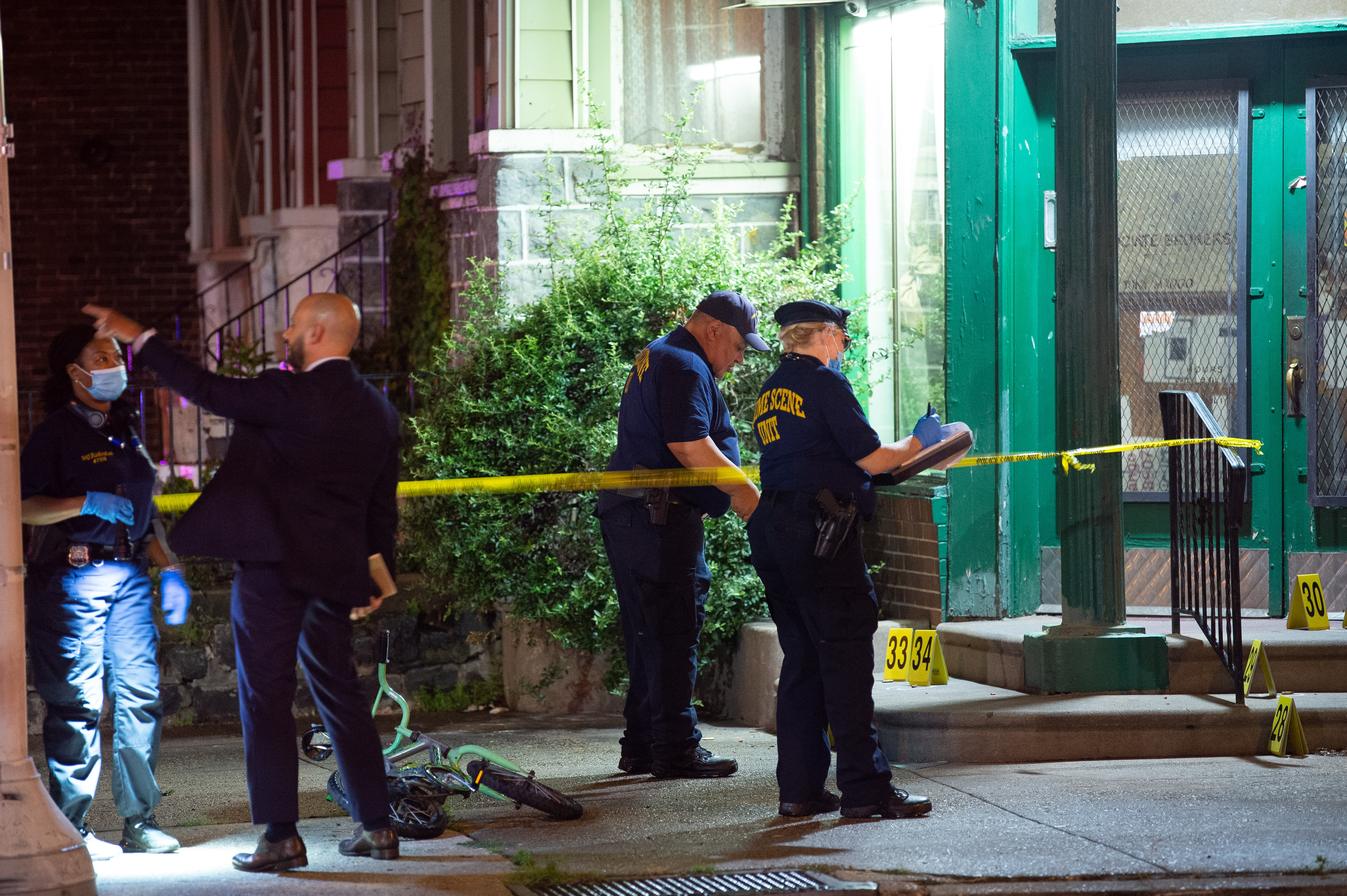 Police officials work at the scene of a mass shooting in the Kingsessing section of South Philadelphia