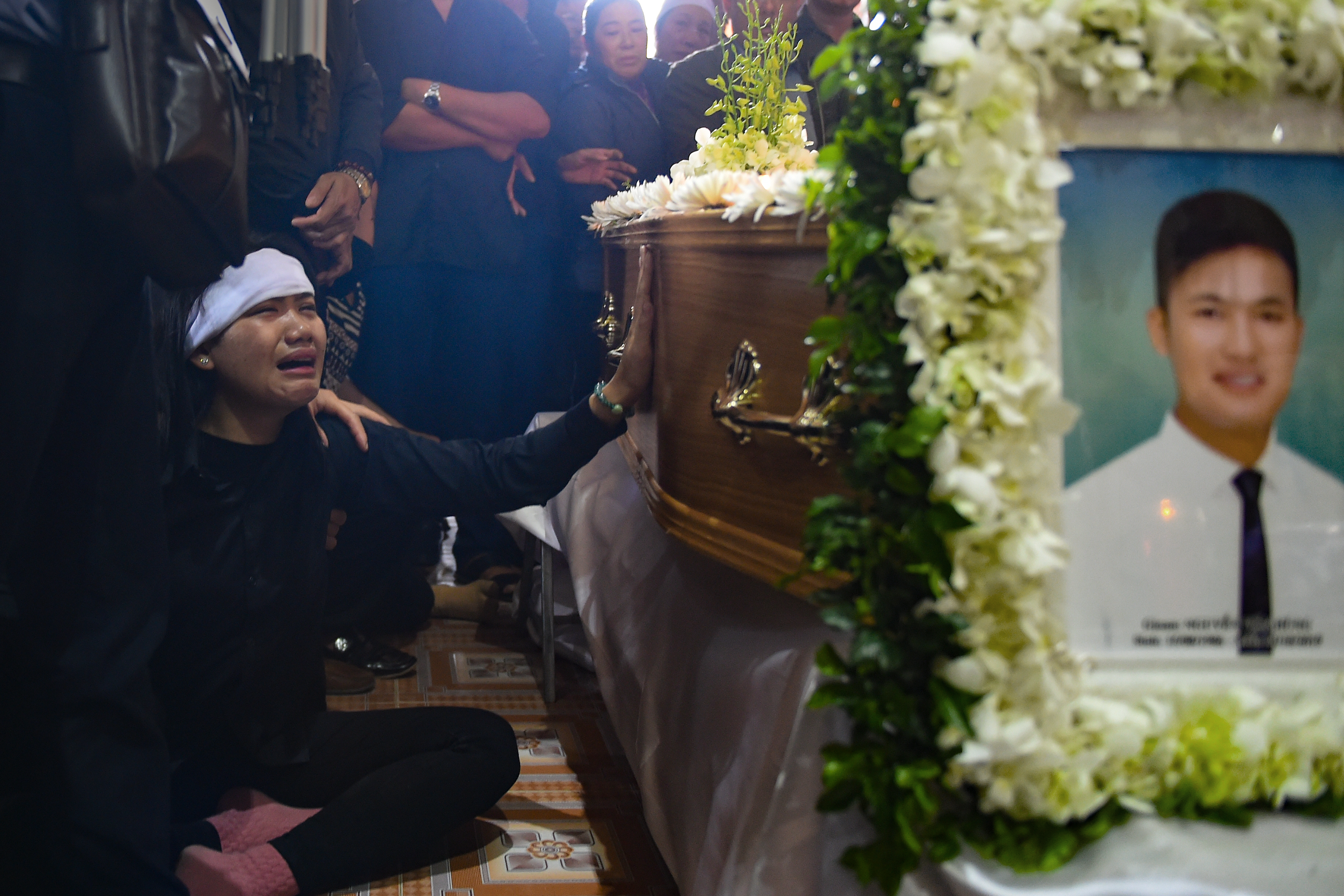 A family member cries before the coffin bearing the remains of Nguyen Van Hung during a funeral service at a church in Dien Chau district, Nghe An province on November 28, 2019. - The families of some of the 39 Vietnamese people found dead in a truck in Britain prepared for emotional burials for their children November 28 after an agonising weeks-long wait to bring their bodies home. (Photo by Nhac NGUYEN / AFP) / The erroneous mention[s] appearing in the metadata of this photo by Nhac NGUYEN has been modified in AFP systems in the following manner: [remains of Nguyen Van Hung] instead of [Hoang Van Tiep]. Please immediately remove the erroneous mention[s] from all your online services and delete it (them) from your servers. If you have been authorized by AFP to distribute it (them) to third parties, please ensure that the same actions are carried out by them. Failure to promptly comply with these instructions will entail liability on your part for any continued or post notification usage. Therefore we thank you very much for all your attention and prompt action. We are sorry for the inconvenience this notification may cause and remain at your disposal for any further information you may require.