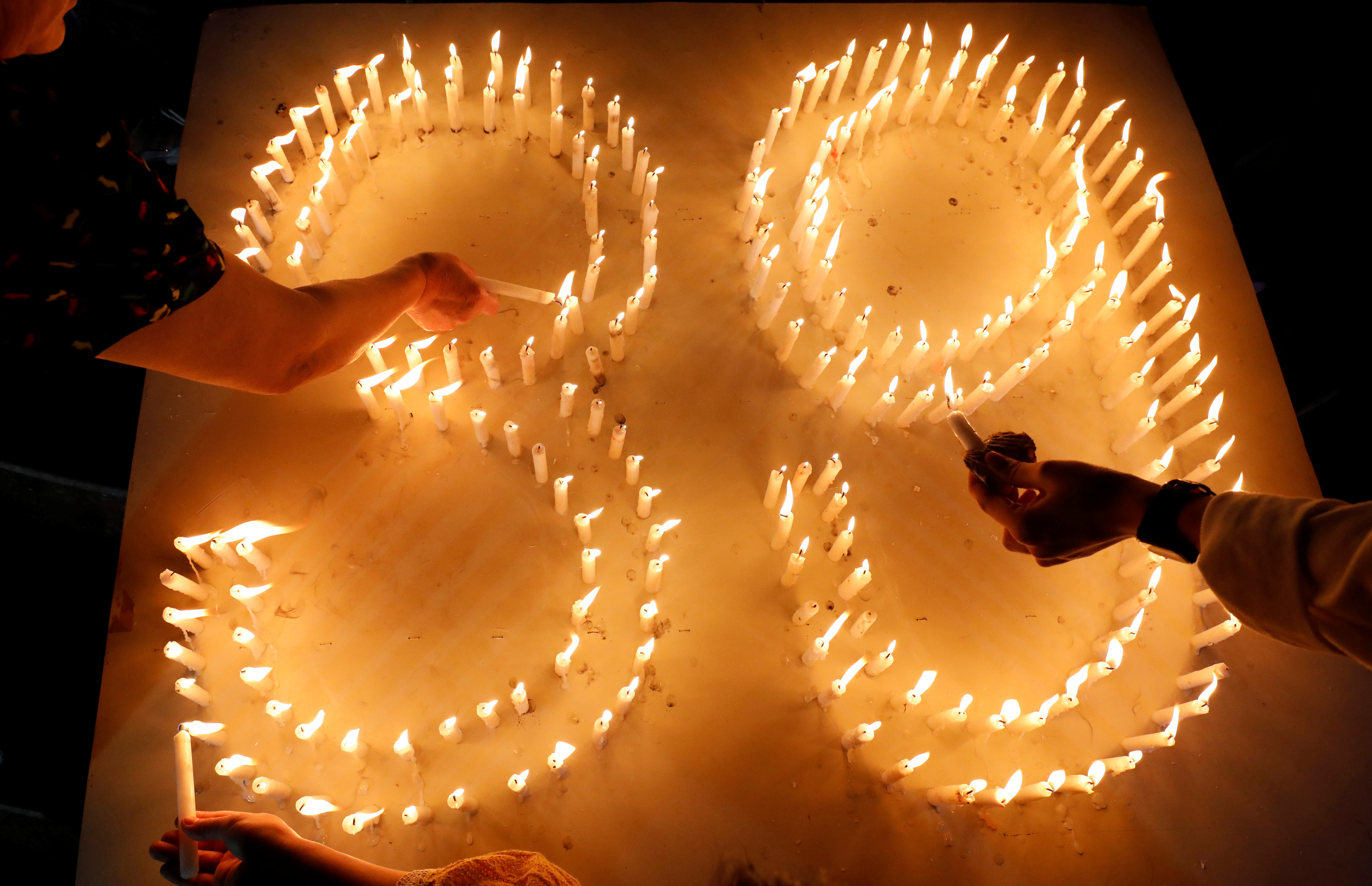 Catholic believers light candles during a mass prayer for 39 Vietnamese people found dead in a truck near London last month, at a church in Nghe An province, Vietnam November 30, 2019. REUTERS/Kham