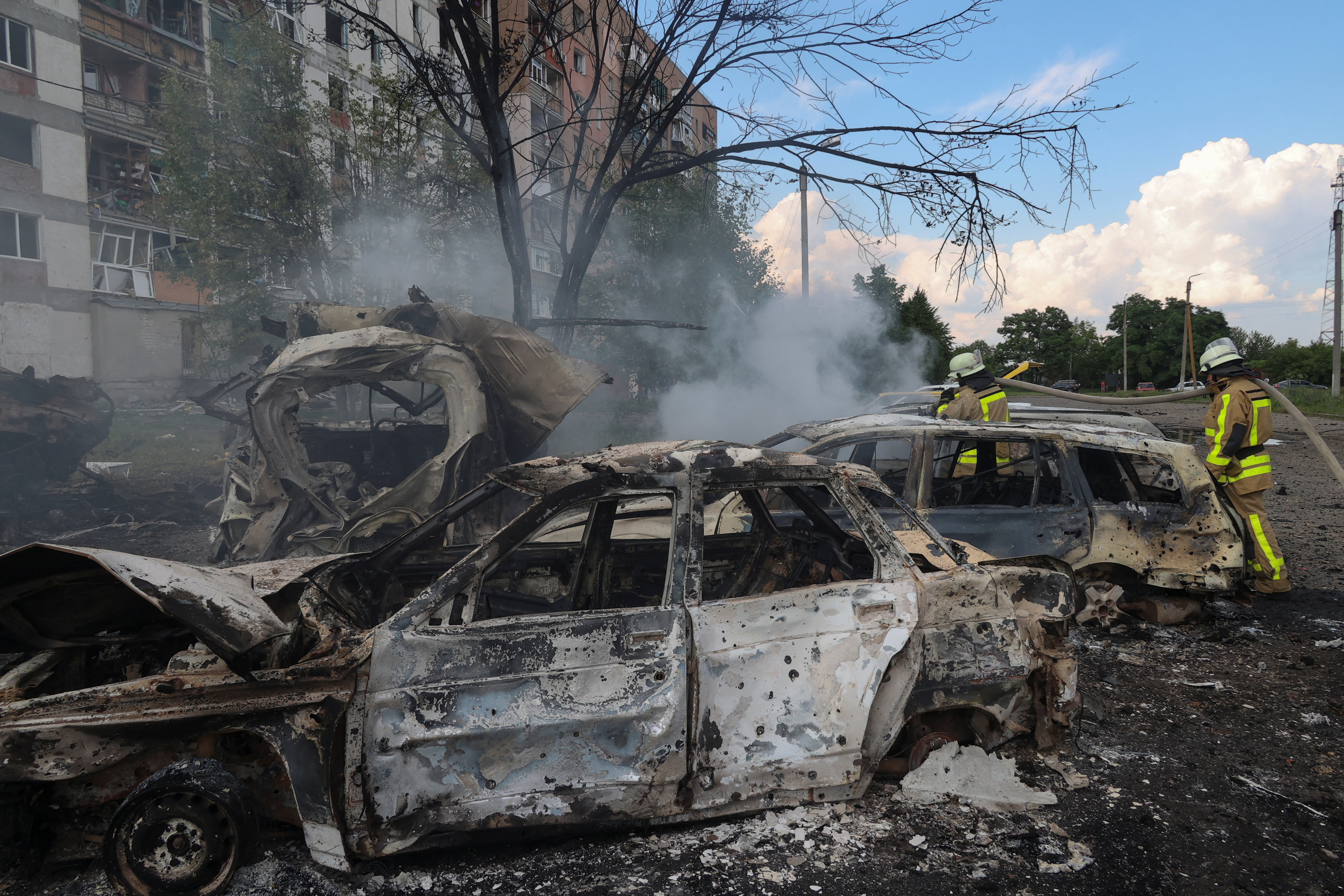 A smouldering car outside a block of flats hit by a Russian missile strike.