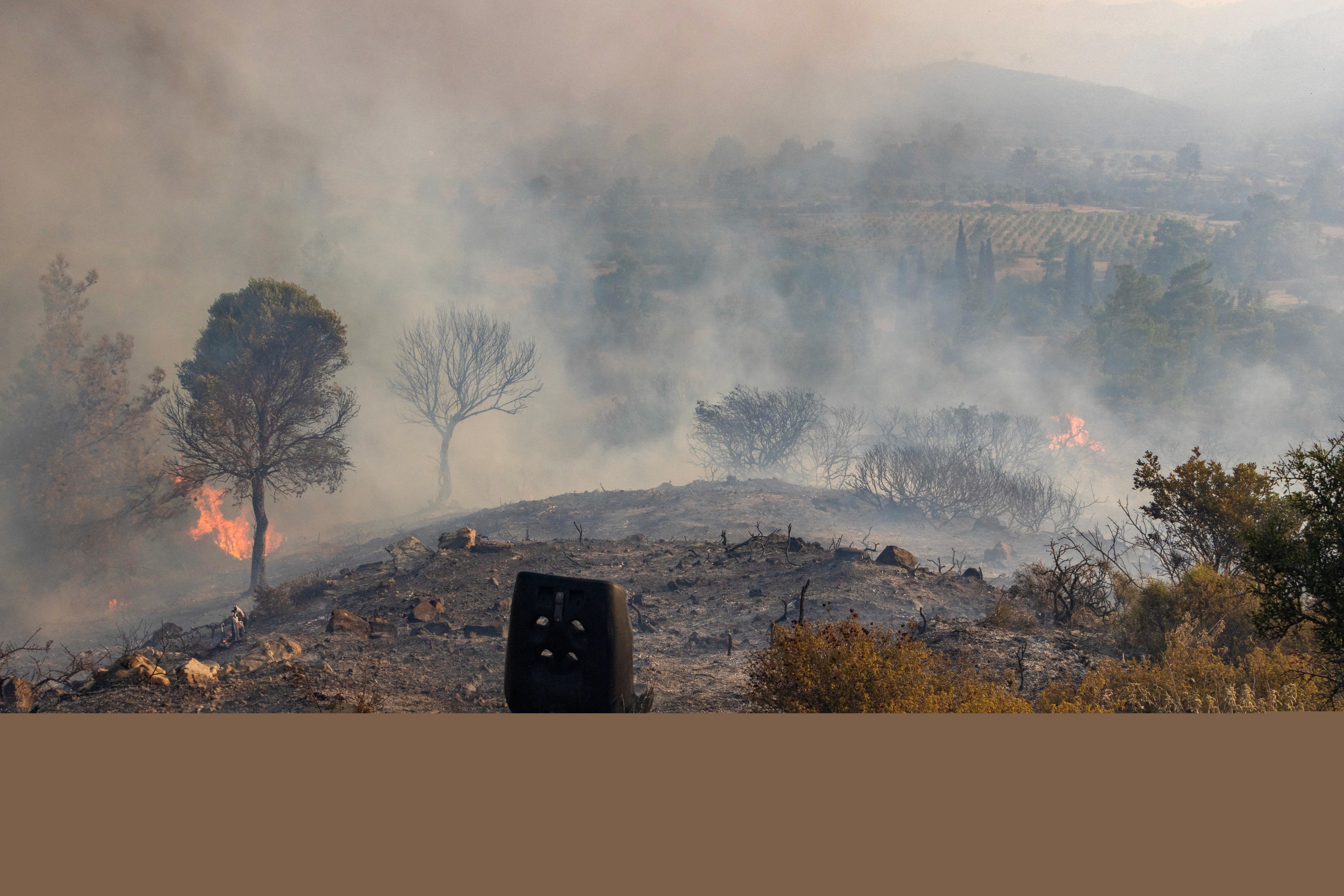 Flames and smoke rise as a wildfire burns near the village of Asklipieio
