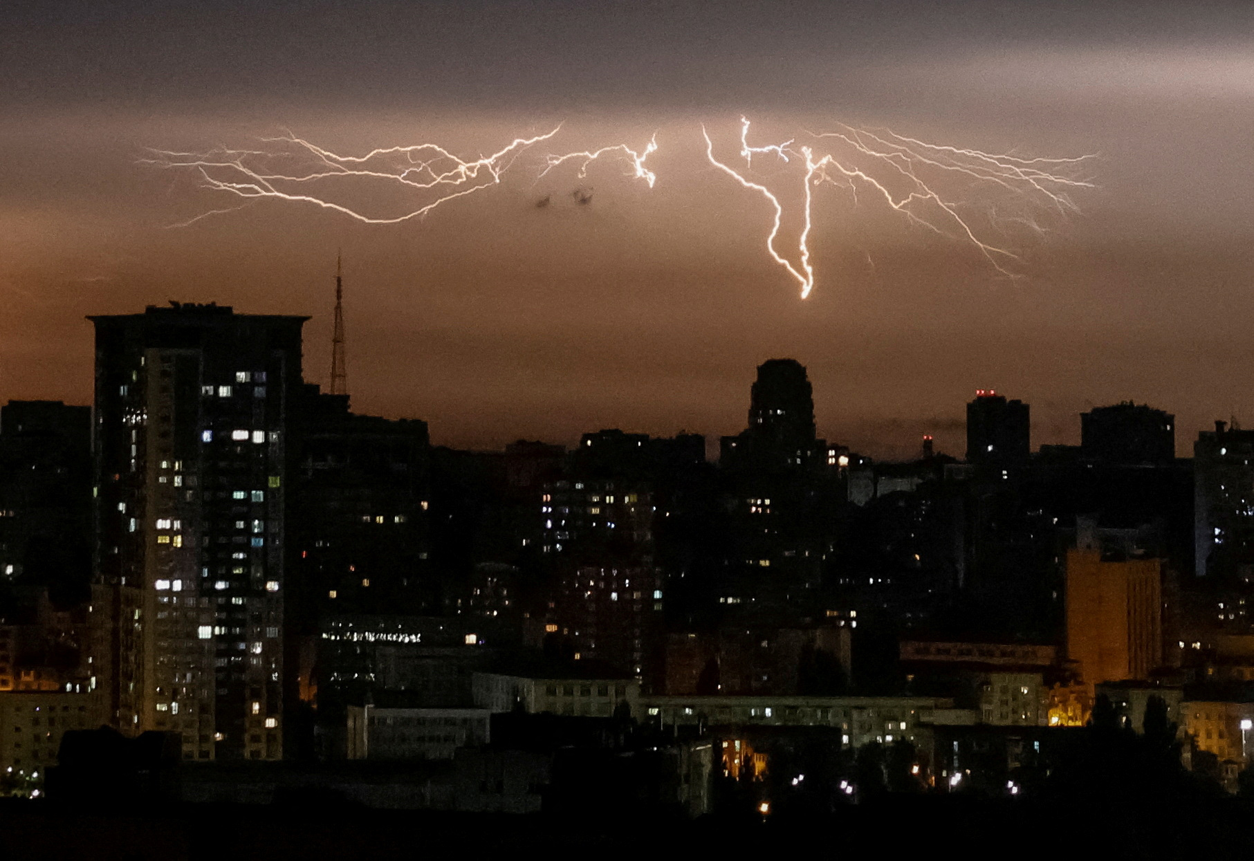 Lightnings are seen over the city during a rain in Kyiv, Ukraine July 26, 2023. REUTERS/Gleb Garanich TPX IMAGES OF THE DAY