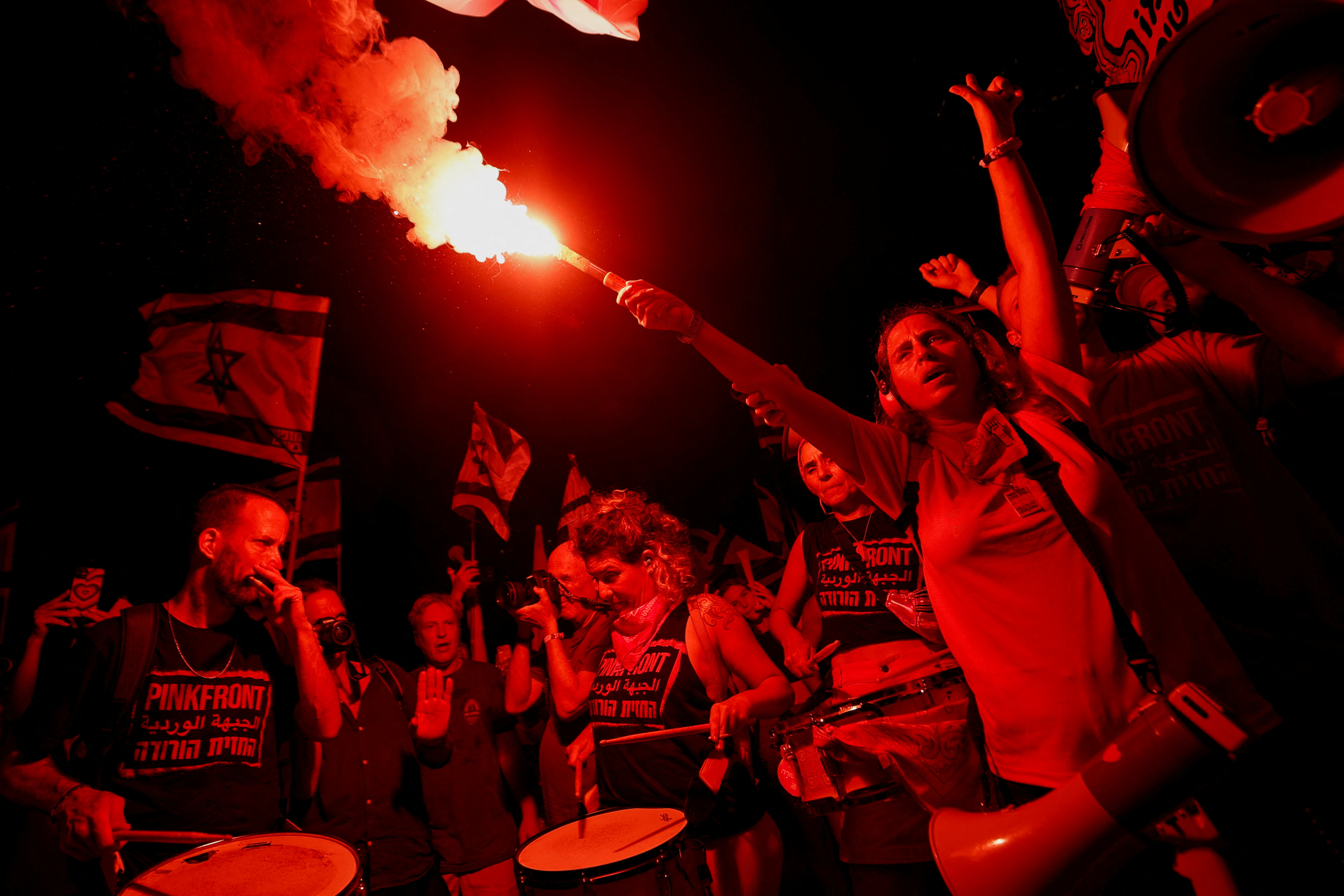 A protester holds a flare during a demonstration against Israeli Prime Minister Benjamin Netanyahu and his nationalist coalition government's judicial overhaul