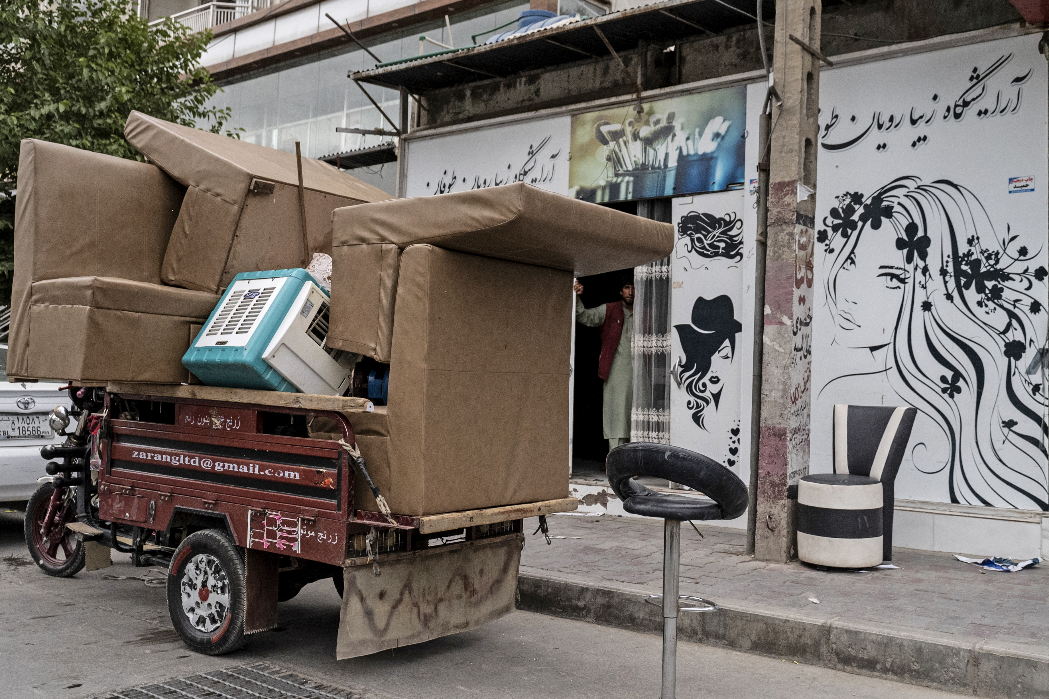 A three-wheeler vehicle loaded with belongings from a beauty parlour