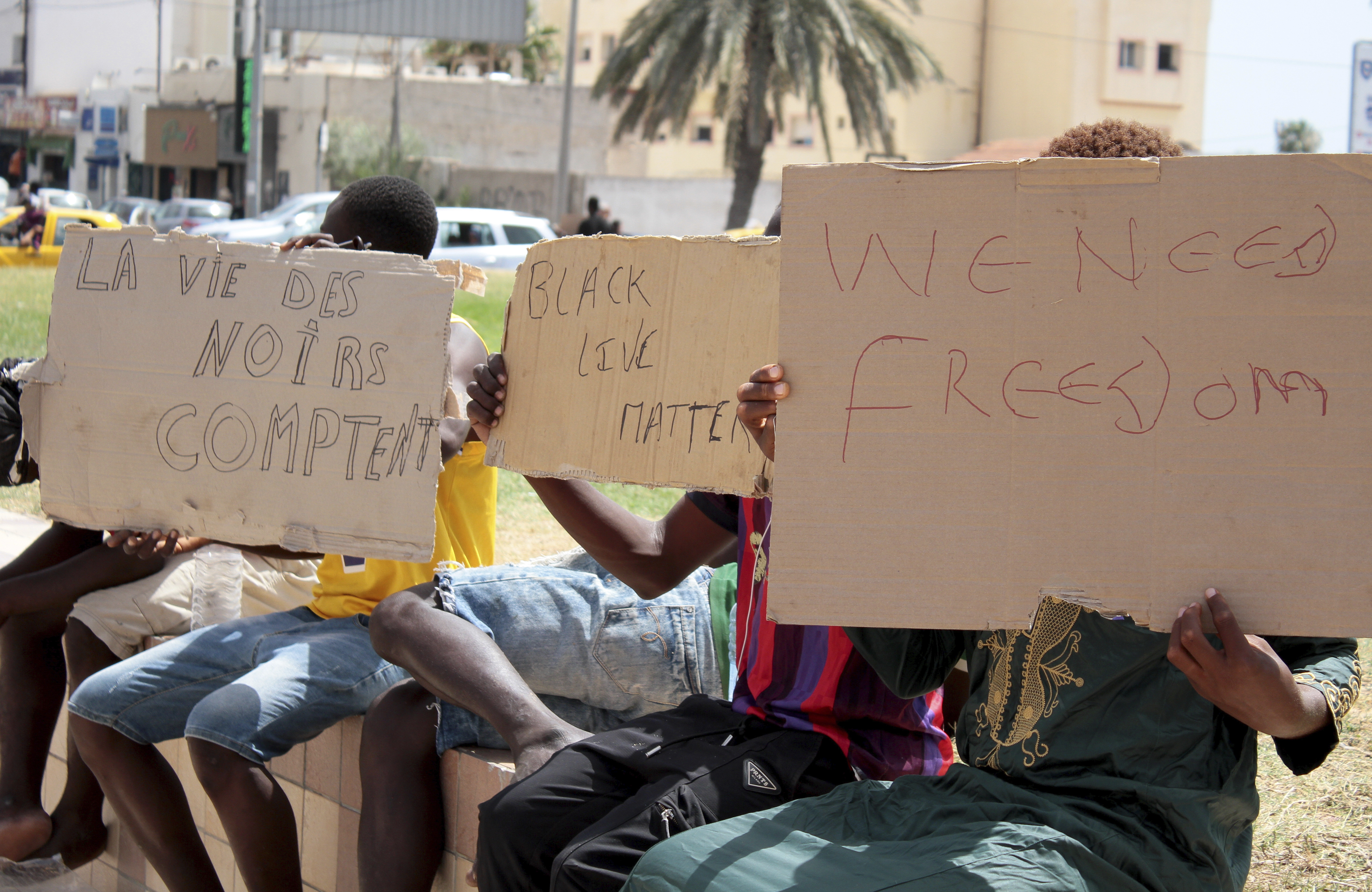 Migrants hold placards reading "Black Lives Matter" during a gathering in Sfax, Tunisia's eastern coast