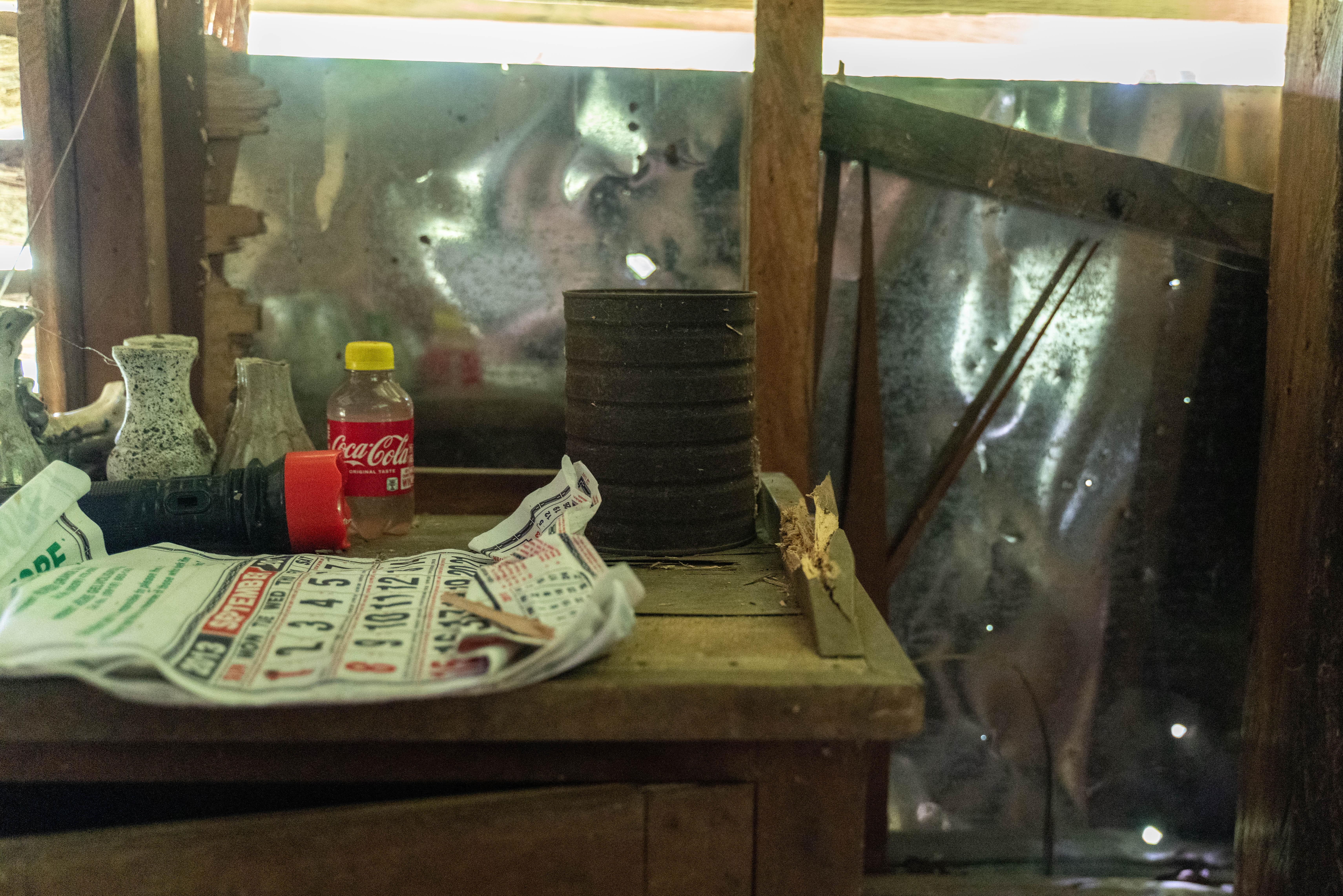Light shining through multiple bullet holds in the walls of the Tingal's home.