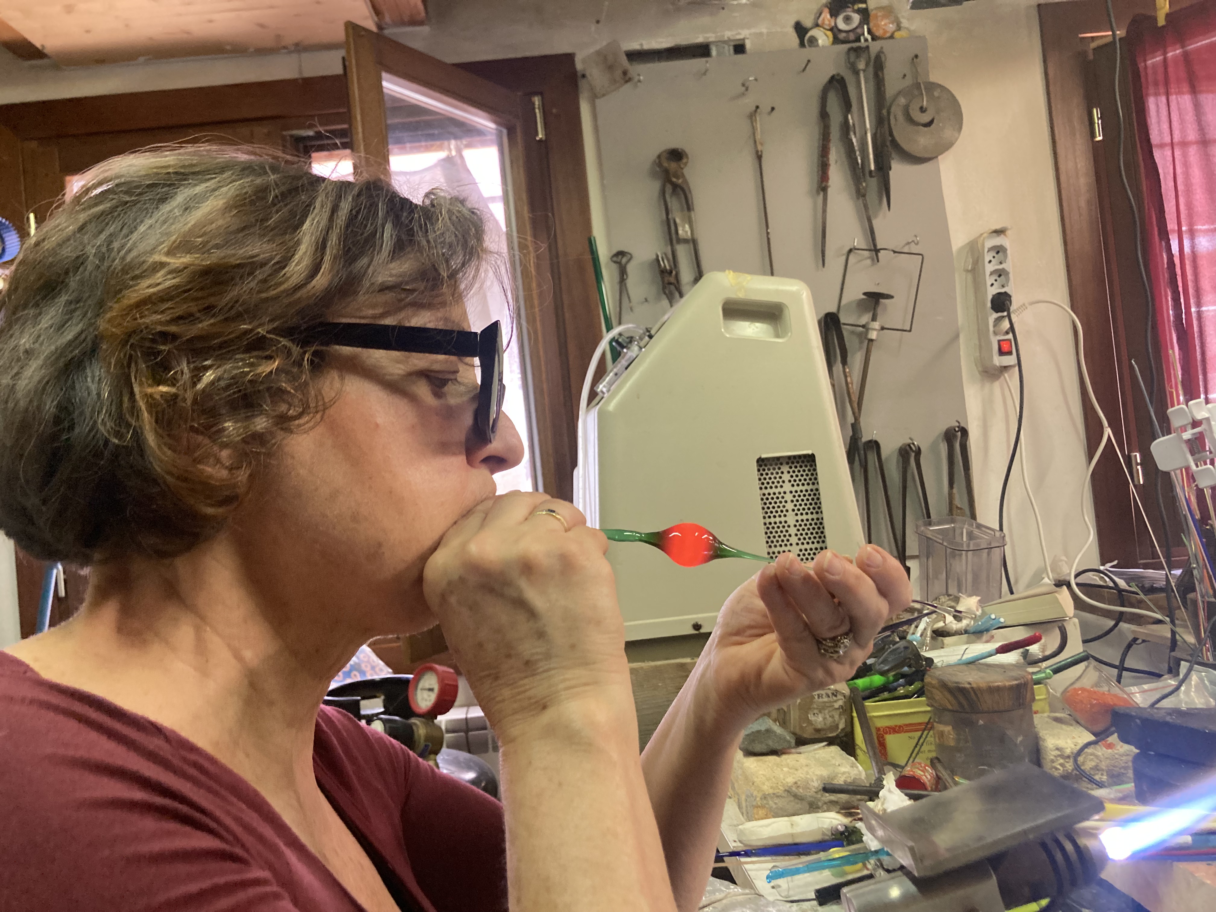 A woman blows glass in Murano