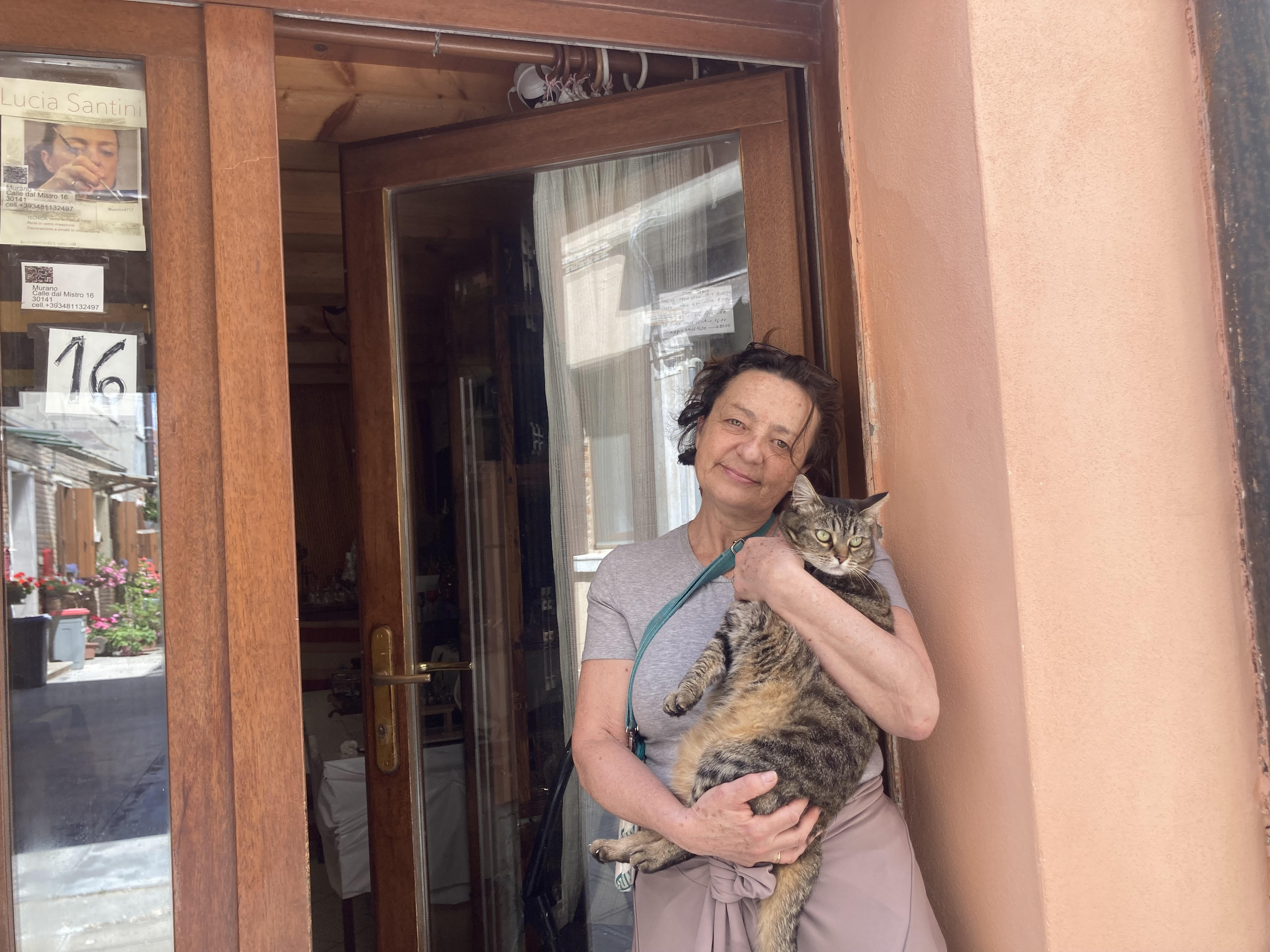 A woman holds up her striped cat