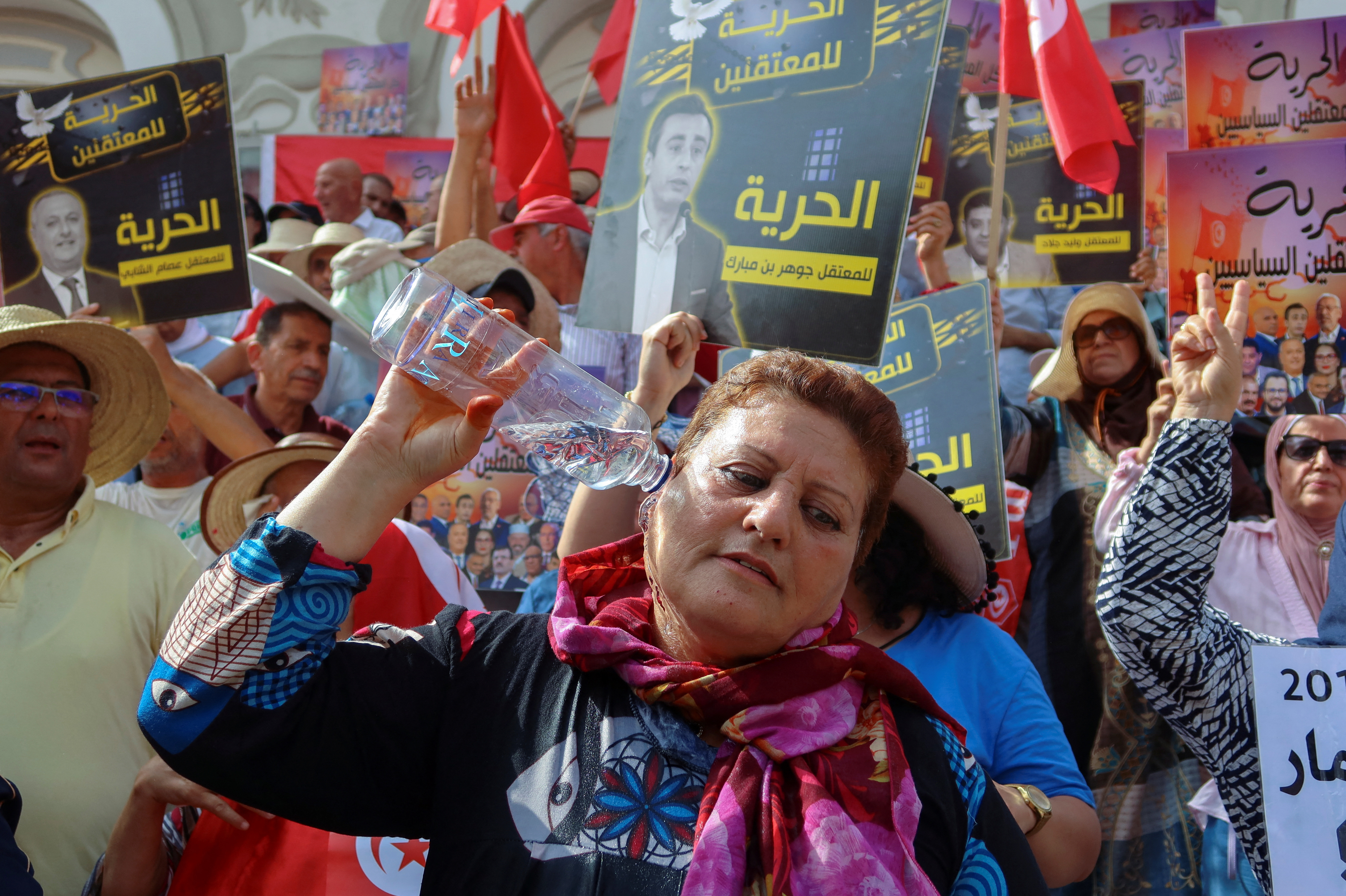 A woman pours water to cool off during a protest