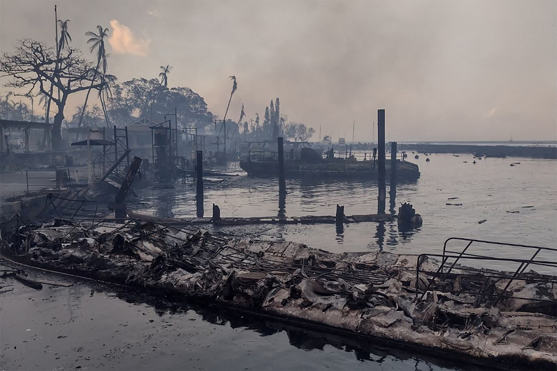 A charred boat lies in the scorched waterfront after wildfires fanned by the winds of a distant hurricane devastated Maui's city of Lahaina, Hawaii