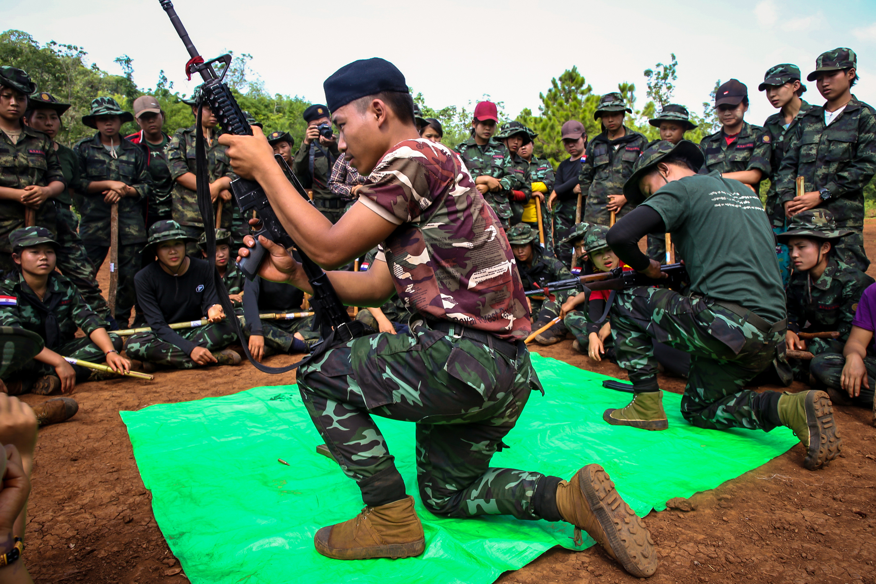 This handout from the Karenni Nationalities Defence Force (KNDF) taken on May 28, 2022 and received on May 30 shows members of the KNDF watching a demonstration on how to operate weapons during a training session for female special forces members and women battalions at their base camp in the forest near Demoso in Myanmar's eastern Kayah state. (Photo by Handout / KARENNI NATIONALITIES DEFENSE FORCE (KNDF) / AFP) / -----EDITORS NOTE --- RESTRICTED TO EDITORIAL USE - MANDATORY CREDIT