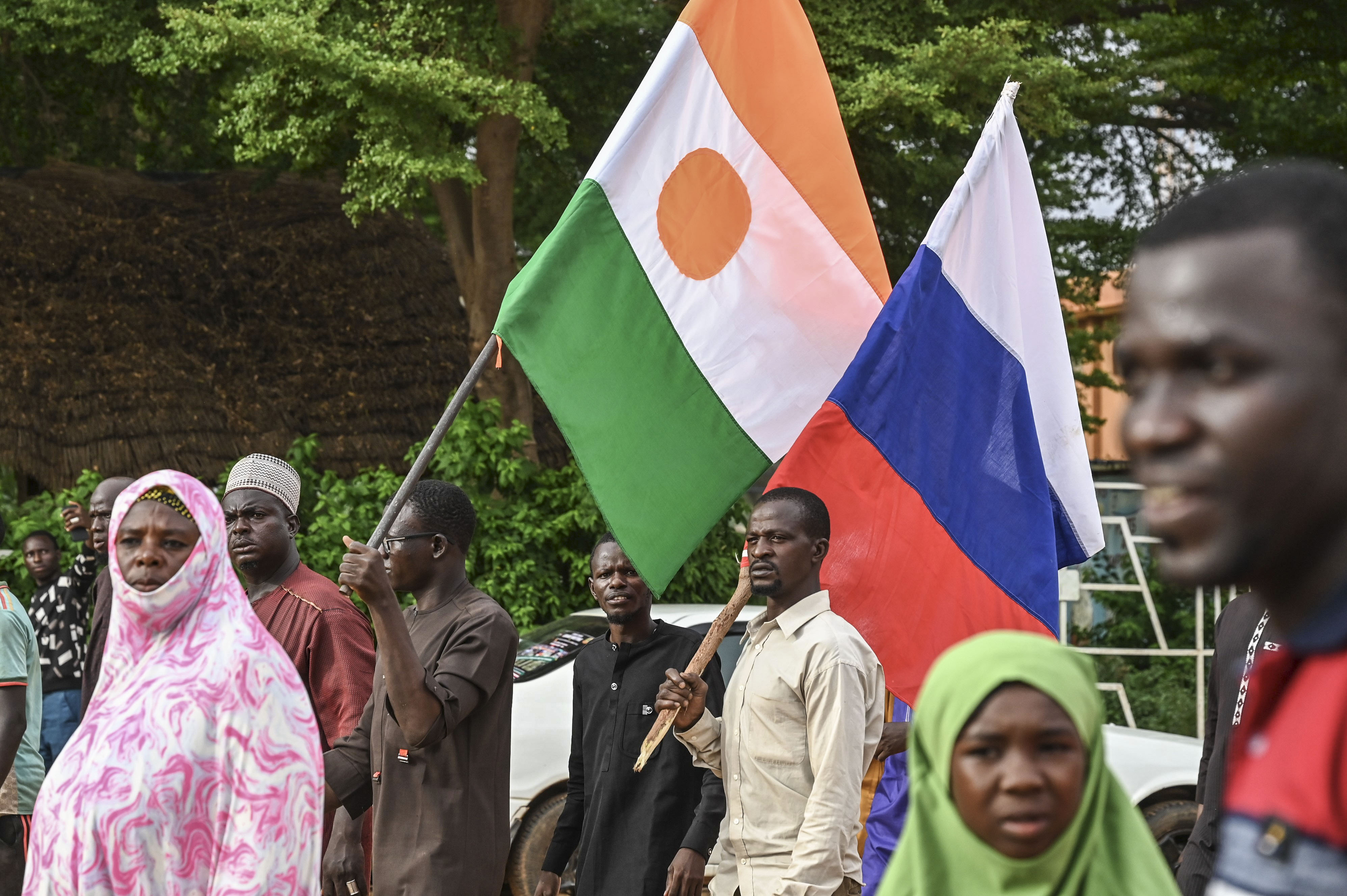 A picture of people in Niger carrying Nigerien and Russian flags.