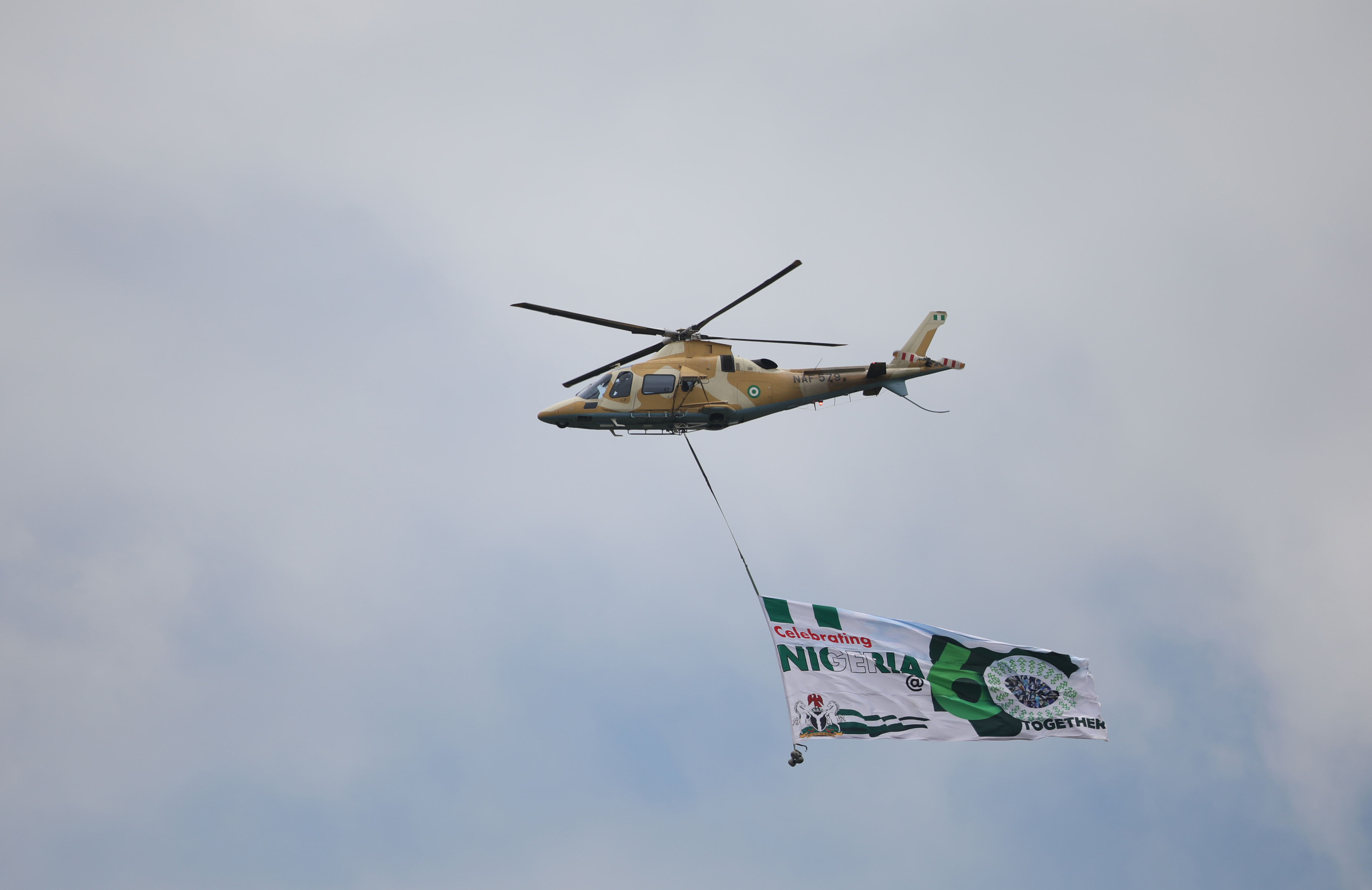 A Nigerian Air force helicopter fly a Nigerian 60th anniversary banner at the Aso-Rock in Abuja