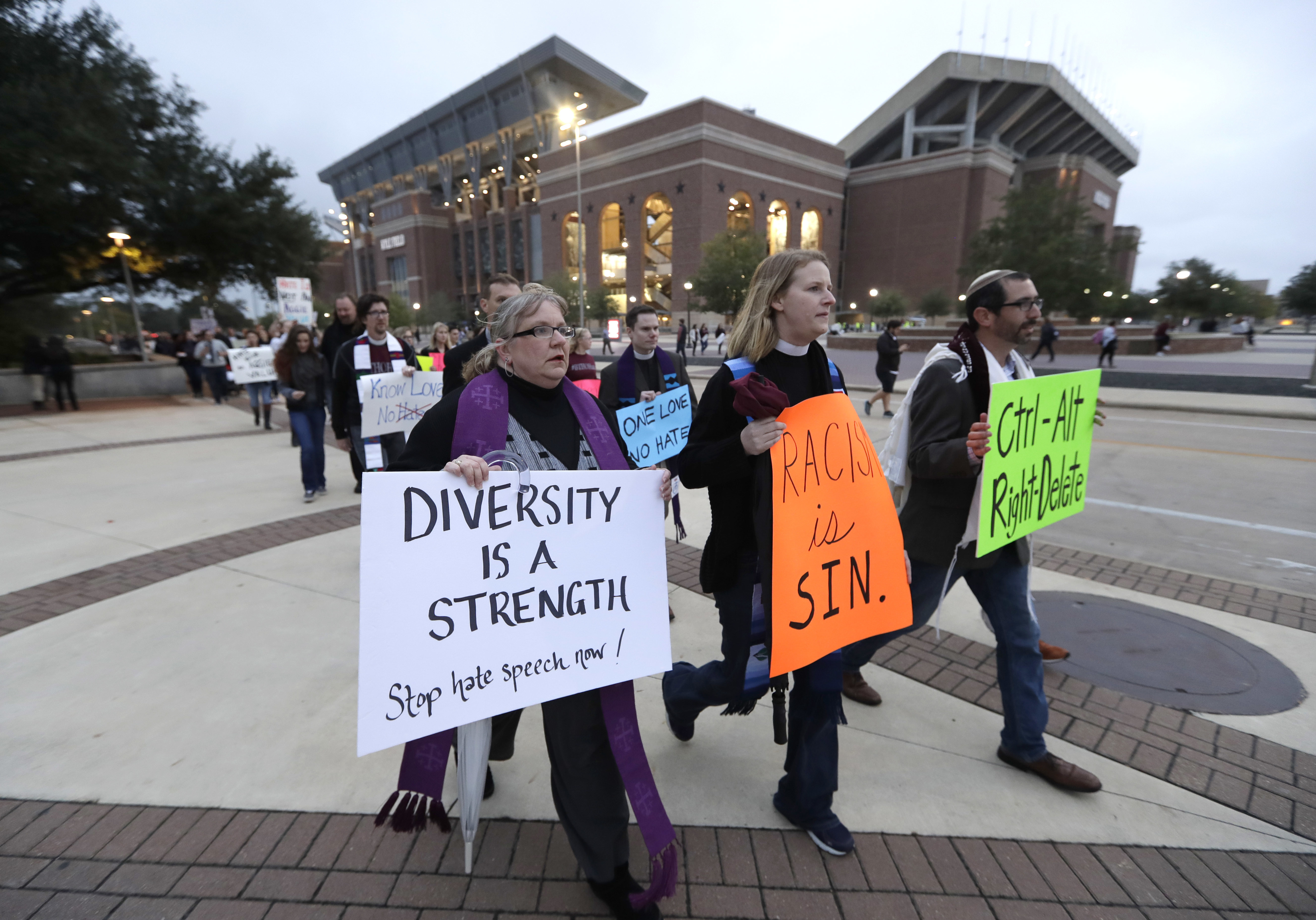 Demonstrators walks past Kyle Field toward the venue where Richard Spencer, who leads a movement that mixes racism, white nationalism and populism, is scheduled to speak at Texas A&M University, Tuesday, Dec. 6, 2016, in College Station, Texas. Spencer is scheduled to speak at Texas A&M University after being invited by a former student. The university is holding a an event to highlight diversity and unity at the same time Spencer is set to speak. (AP Photo/David J. Phillip)