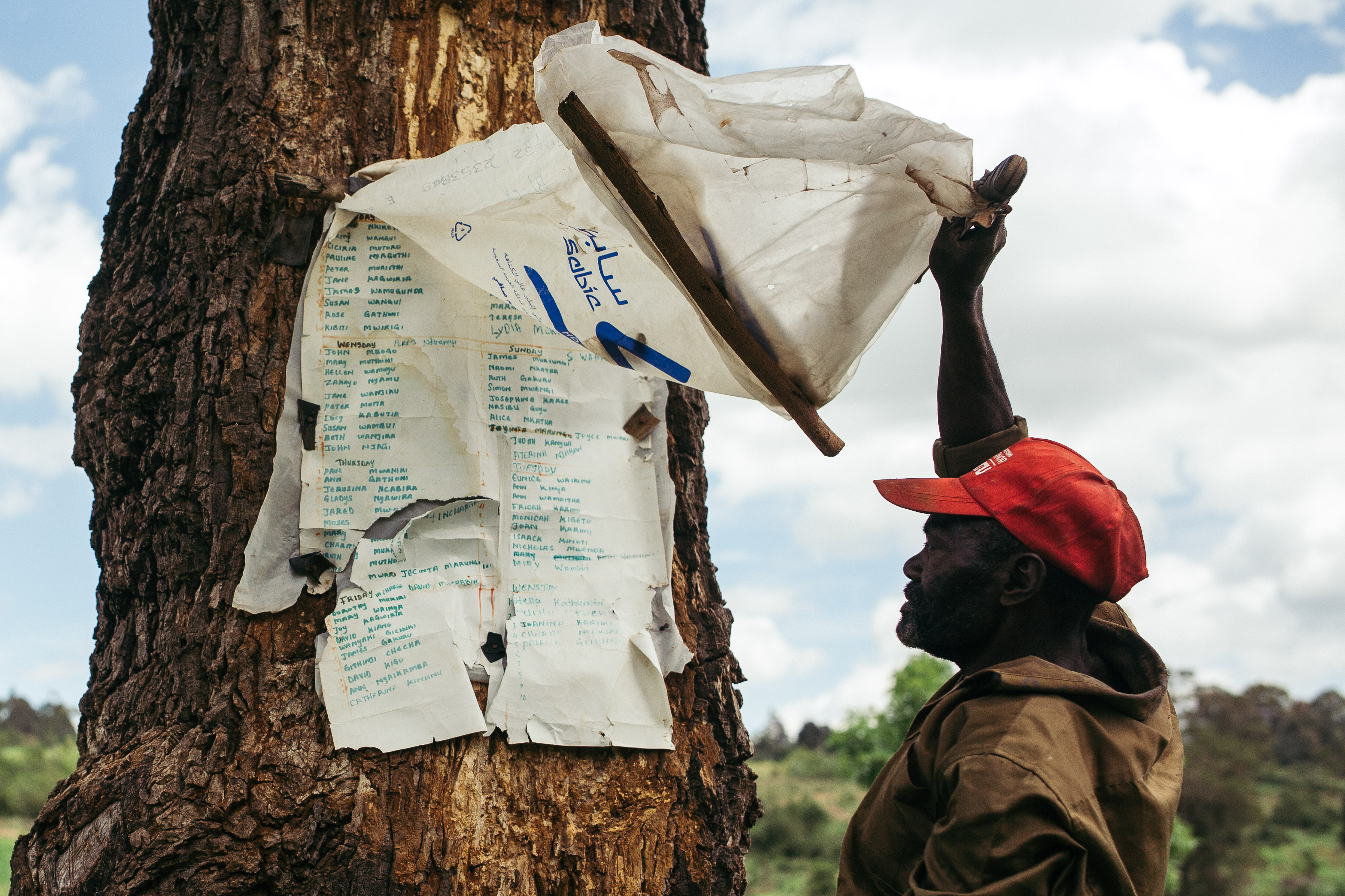 A community member living near the Nanyuki barracks at one of KDF's nurseries, showing the time chart that he shares with other volunteers