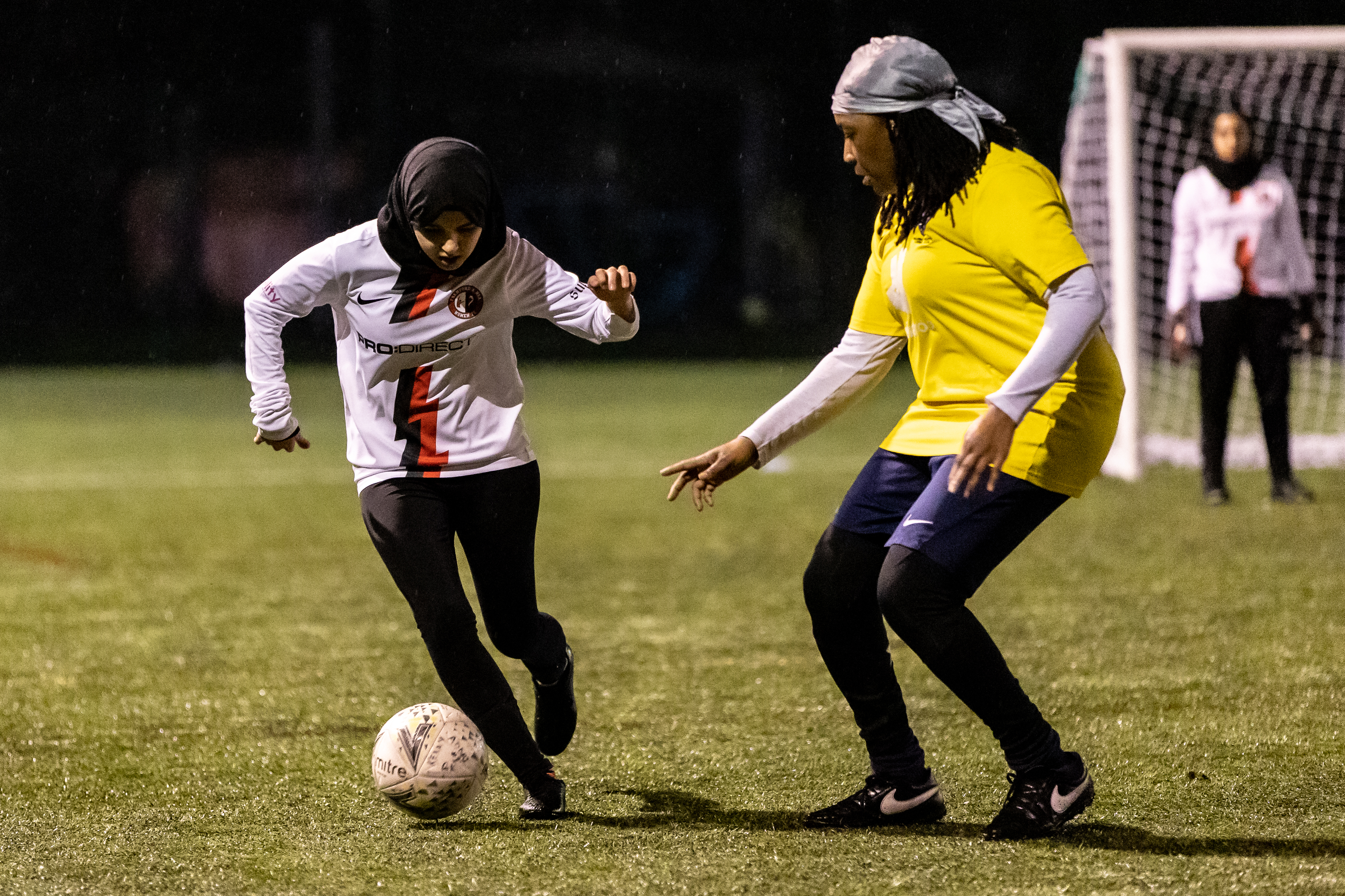 Two girls play football