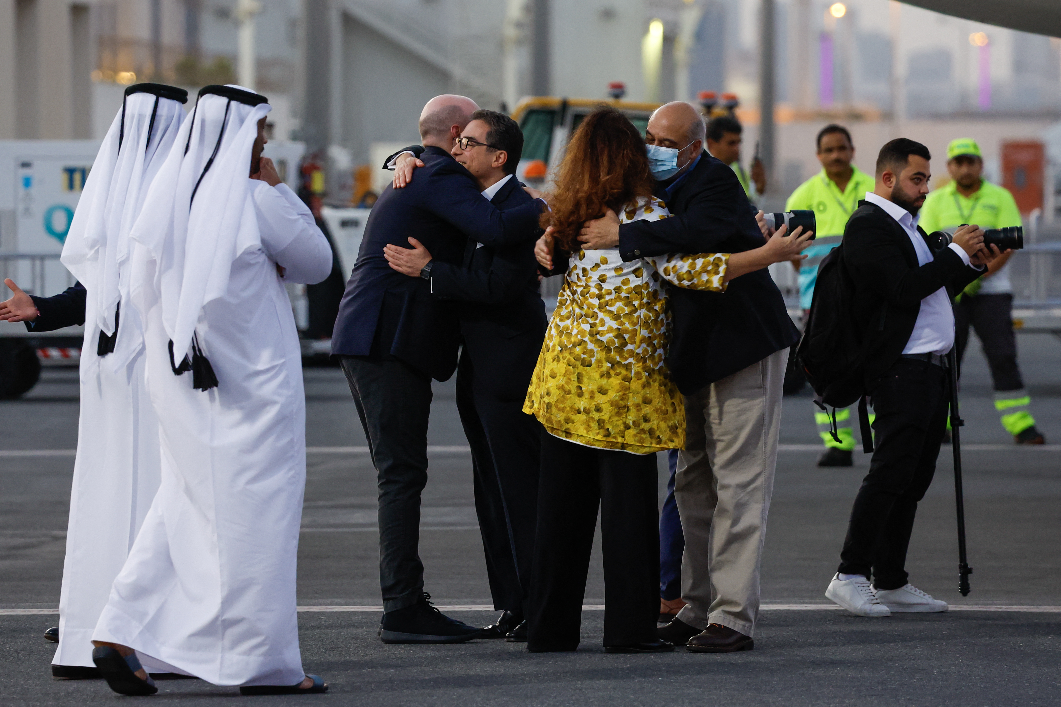 US citizens Siamak Namazi (C-with glasses) and Morad Tahbaz are greeted upon their arrival at the Doha International Airport in Doha on September 18, 2023. - Five US detainees, three previously identified as Siamak Namazi, Morad Tahbaz and Emad Sharqi and two who wish to remain anonymous, released by Iran landed in Doha in a prisoner swap on September 18 after $6 billion in frozen funds were transferred to Iranian accounts in Qatar. 