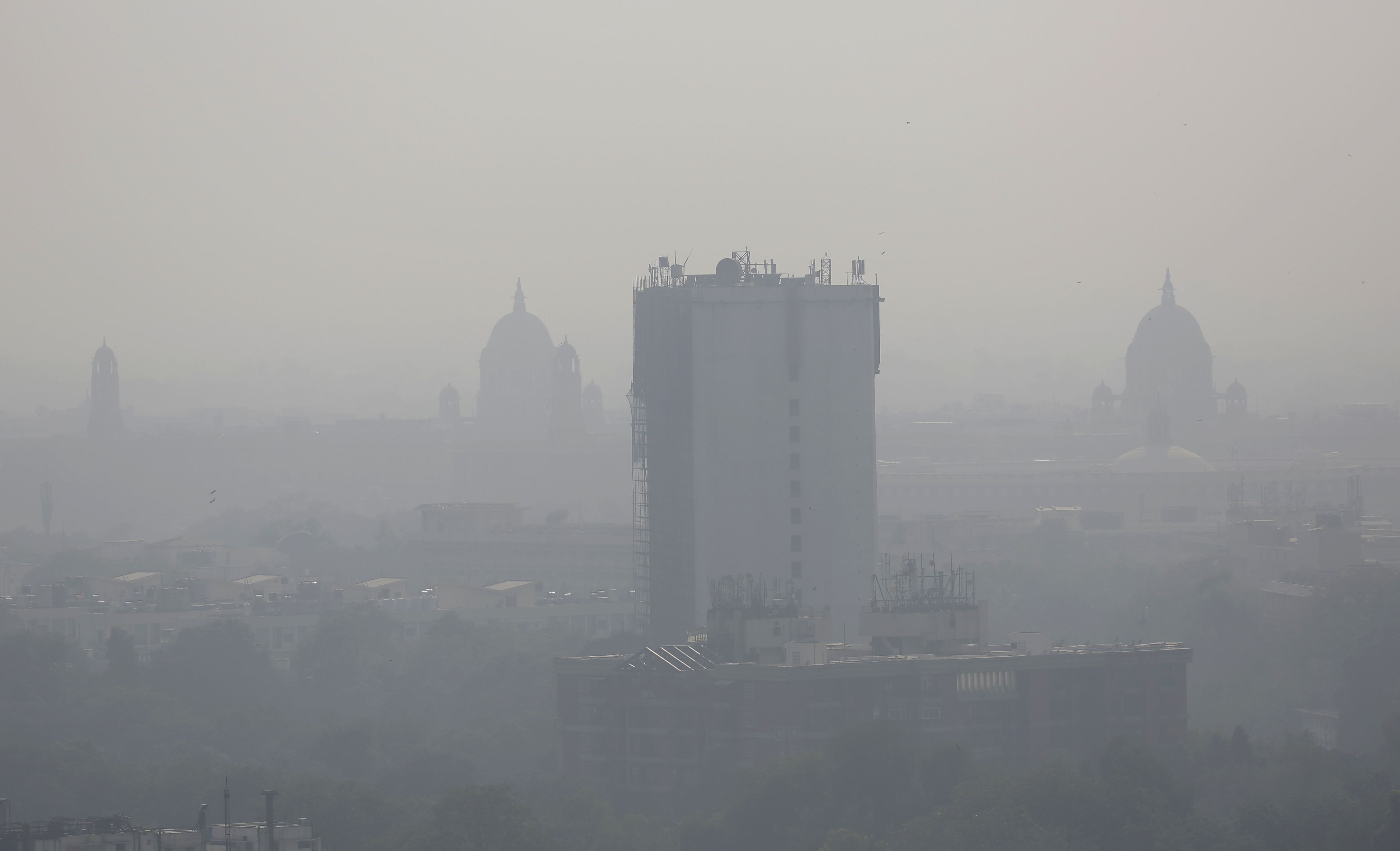 In this photo taken Friday, Oct. 28, 2016, a layer of smog envelops the city skyline before Diwali festival in New Delhi, India. As north Indian cities enter the season of high air pollution, a new report is warning about the dangers to children. (AP Photo/Altaf Qadri)