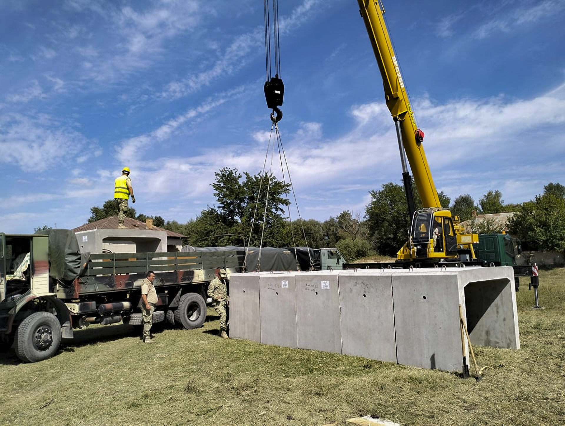 This image released by the Romanian Ministry of Defense (MAPN), shows members of the army's engineering units building concrete shelters in the village of Plauru, on the Danube river border between Romania and Ukraine on Tuesday, Sept. 12, 2023. In the Danube village of Plauru, which is situated opposite Ukraine's Danube port of Izmail, Romania's defense ministry has erected prefabricated concrete shelters for residents, measuring 9.6 meters long, 2 meters wide inside, and 1.5 meter high (about 31 feet long, 6.5 feet wide and 5 feet high). (Romanian Defense Ministry MAPN via AP)
