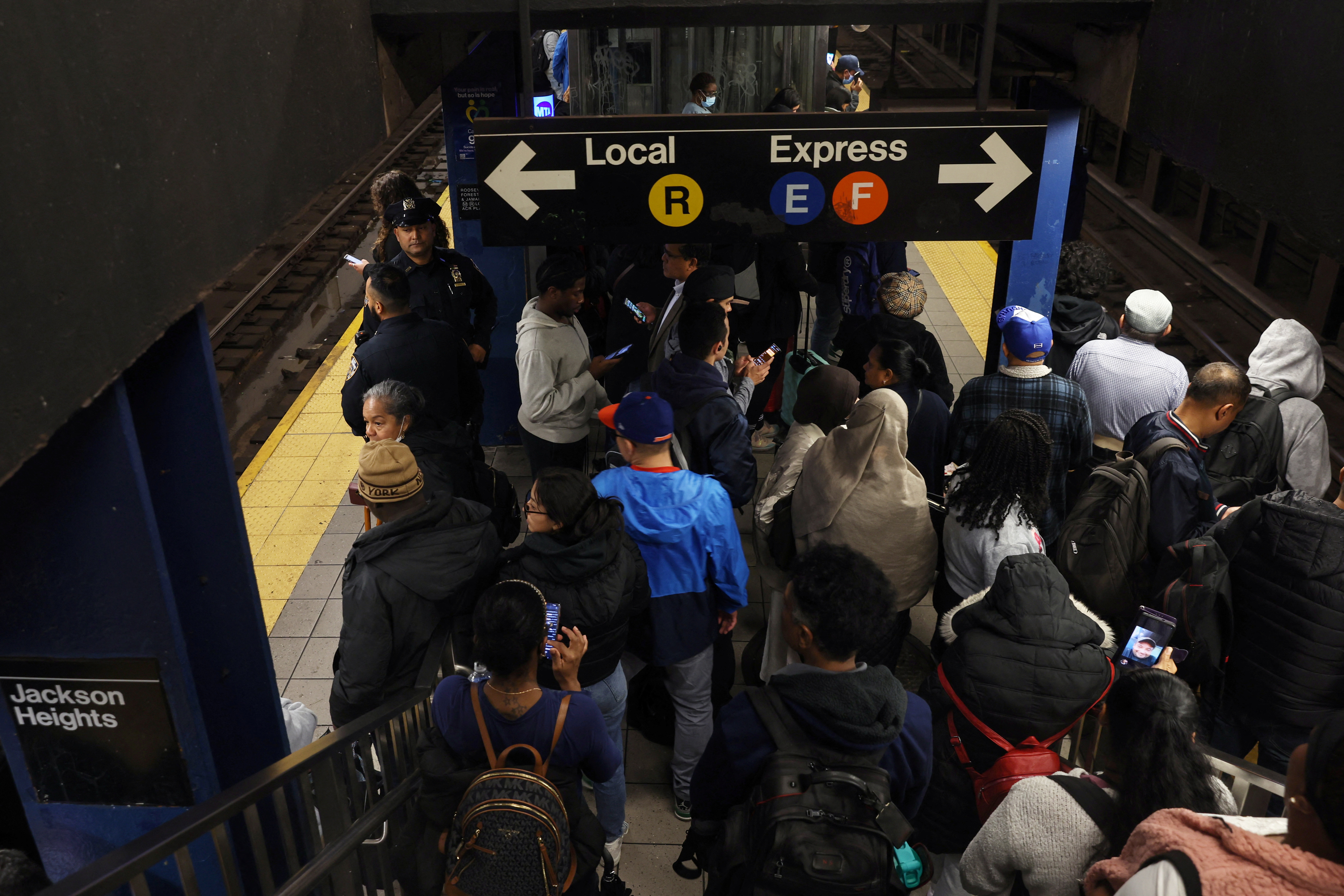 A packed subway platform in New York City, seen from above.