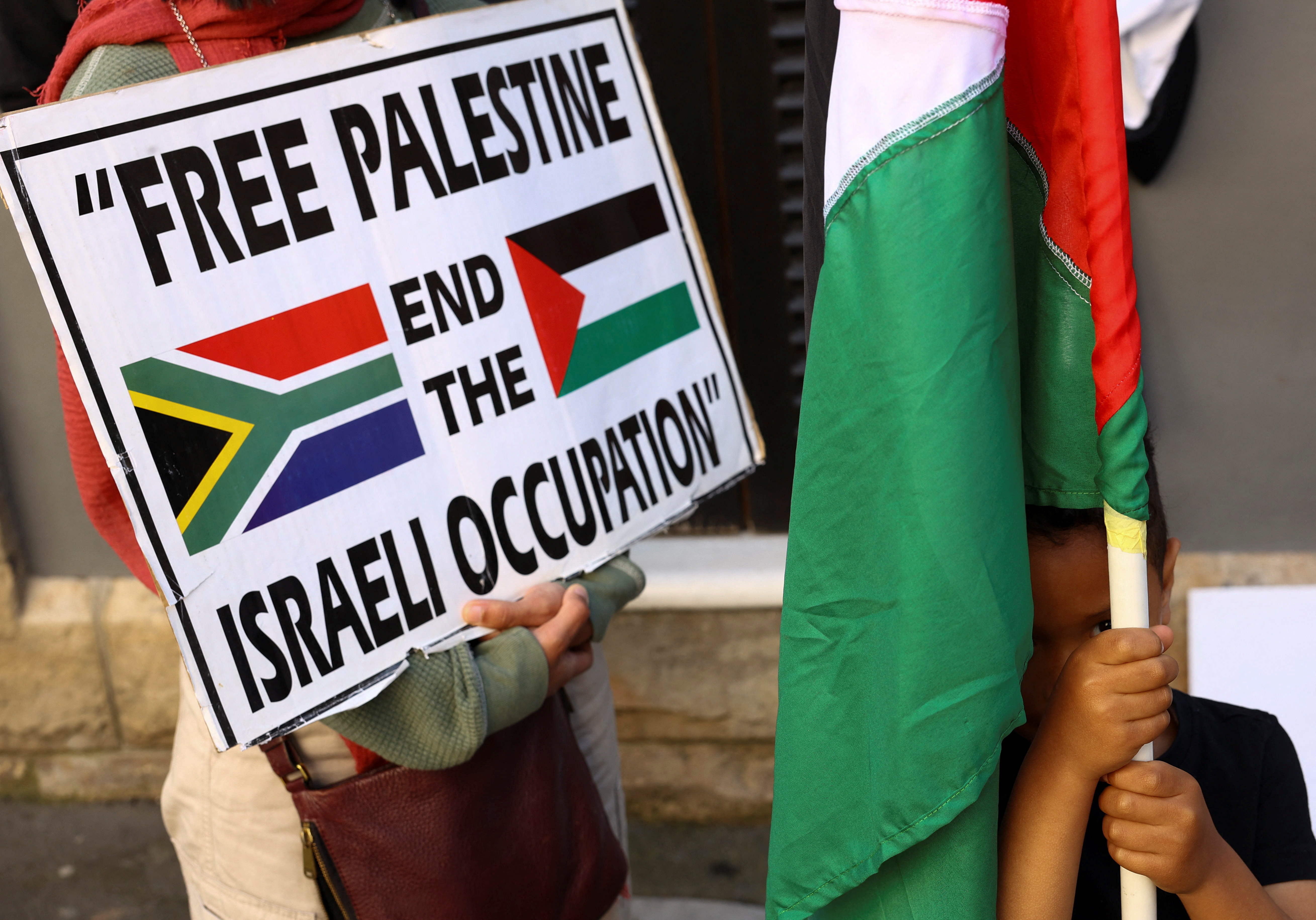 A boy holds a Palestinian flag during a demonstration to express support for the people of Palestine, in Cape Town, South Africa, October 9, 2023. REUTERS/Esa Alexander