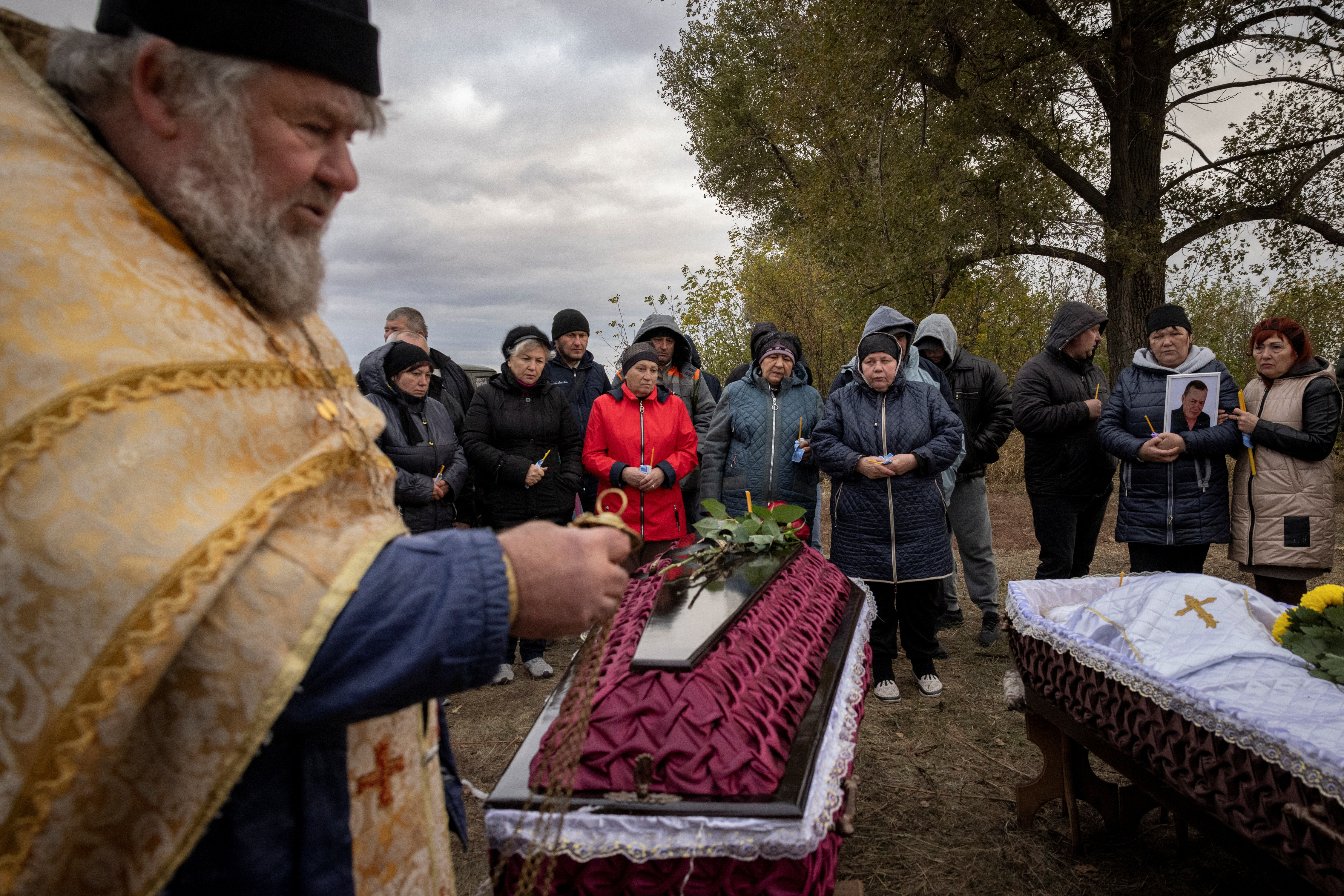 Family and relatives attend the funeral of Iryna Kharbaka and Oleksandr Khodak who were killed in a Russian missile attack, amid Russia's ongoing invasion of Ukraine, at the village cemetery, in the village of Hroza, near Kharkiv, Ukraine October 9, 2023. REUTERS/Thomas Peter