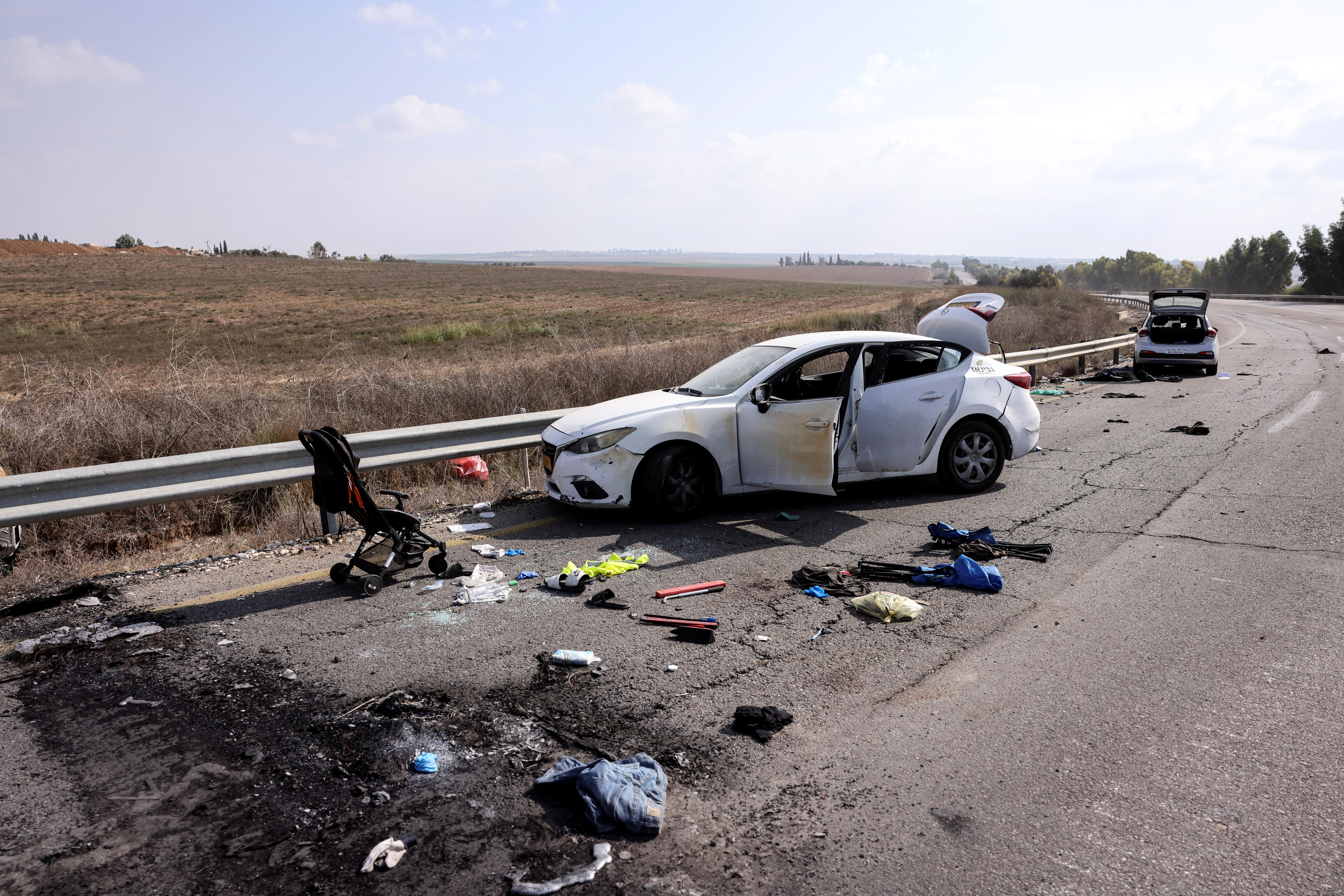 Personal belongings including a child's pram are seen on the road next to a car days after a mass infiltration by Hamas gunmen from the Gaza Strip, near Kibbutz Kfar Aza, in southern Israel