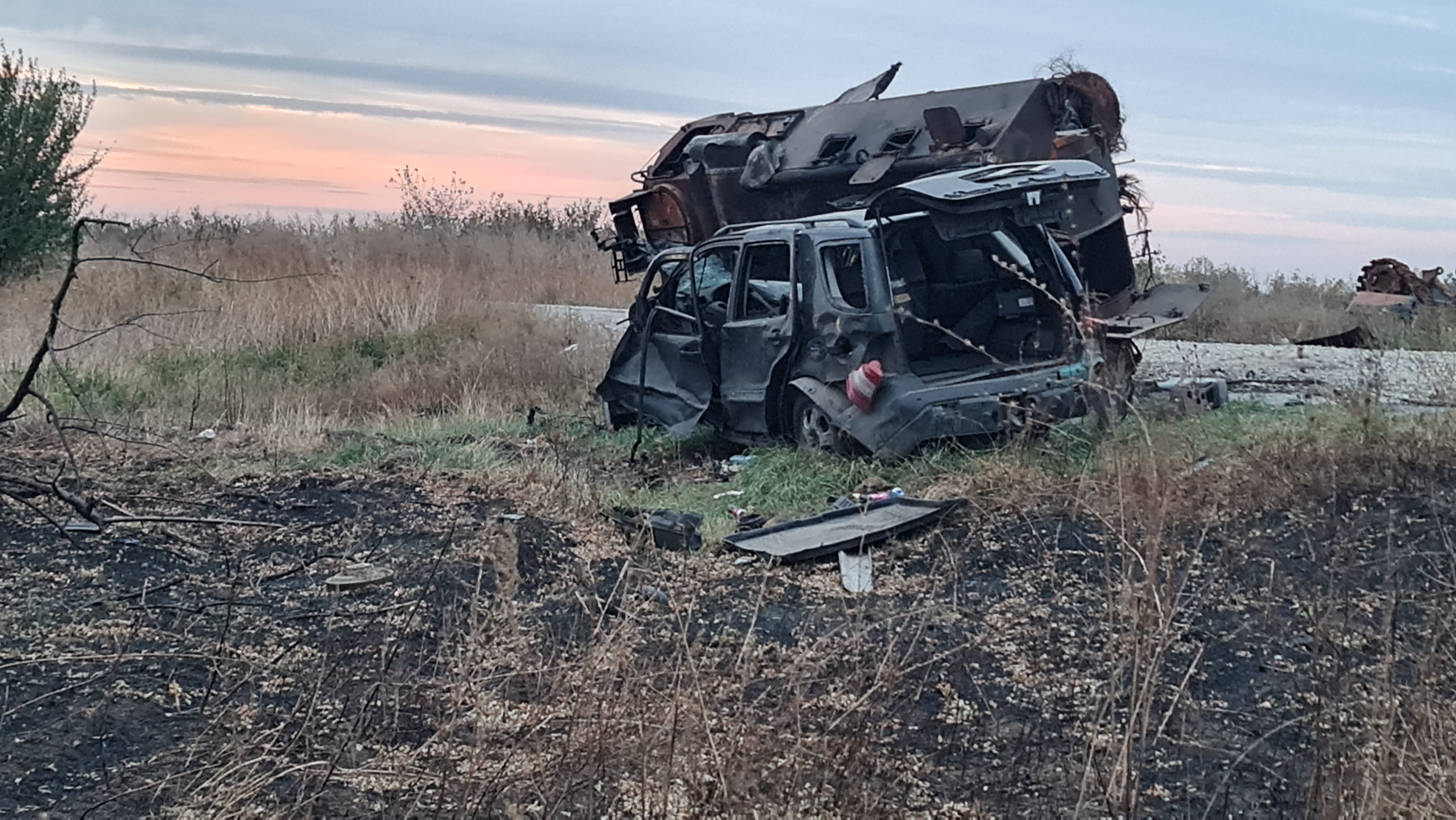 A photo of a van that's been destroyed with another one that's flipped on it's side next to it.
