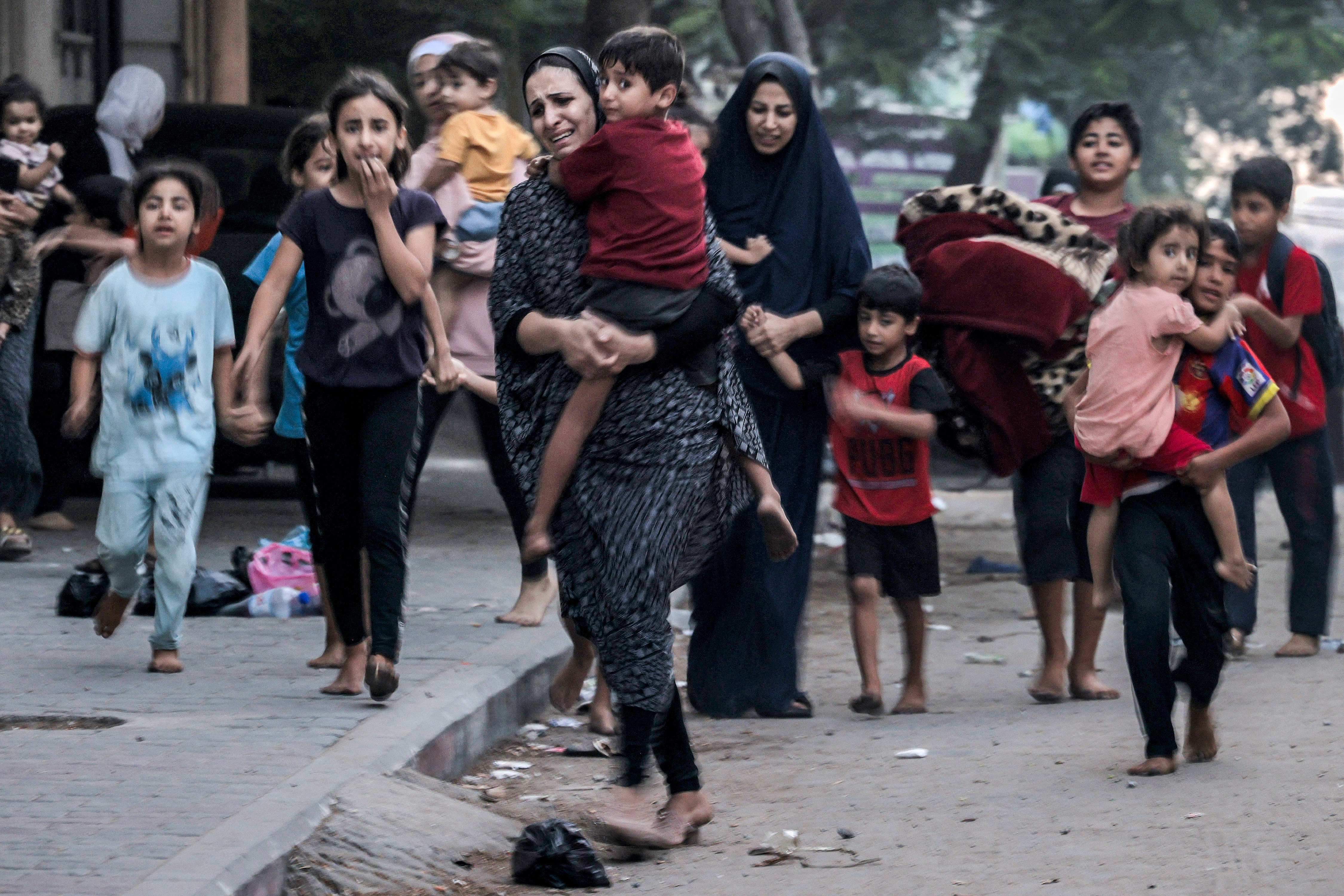 Palestinian women with their children fleeing from their homes following Israeli air strikes